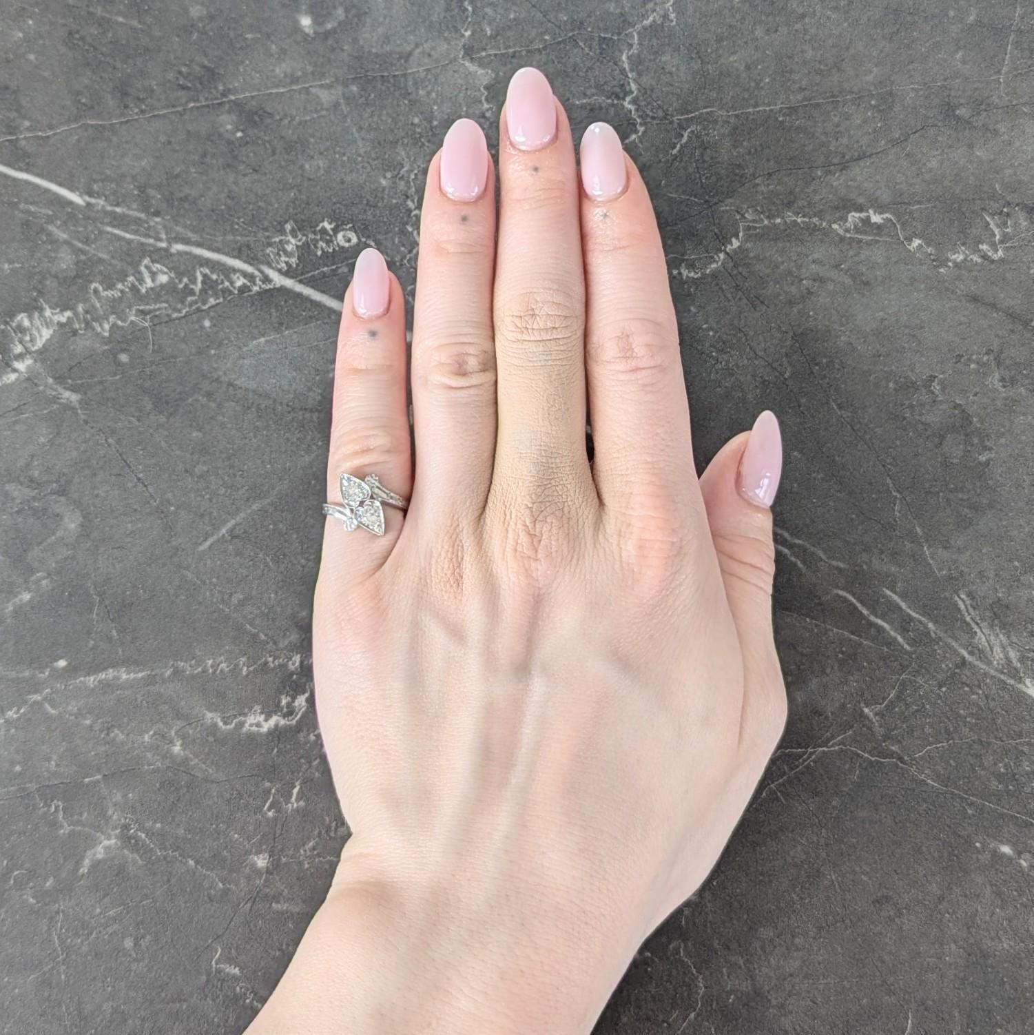 Designed as a white gold bypass ring with heart shaped terminals
Bead set with old European cut diamonds - H/I color with VS2 clarity
Weighing approximately 0.40 carat total
Accented by engraved geometric motif baskets and shoulders
With raised