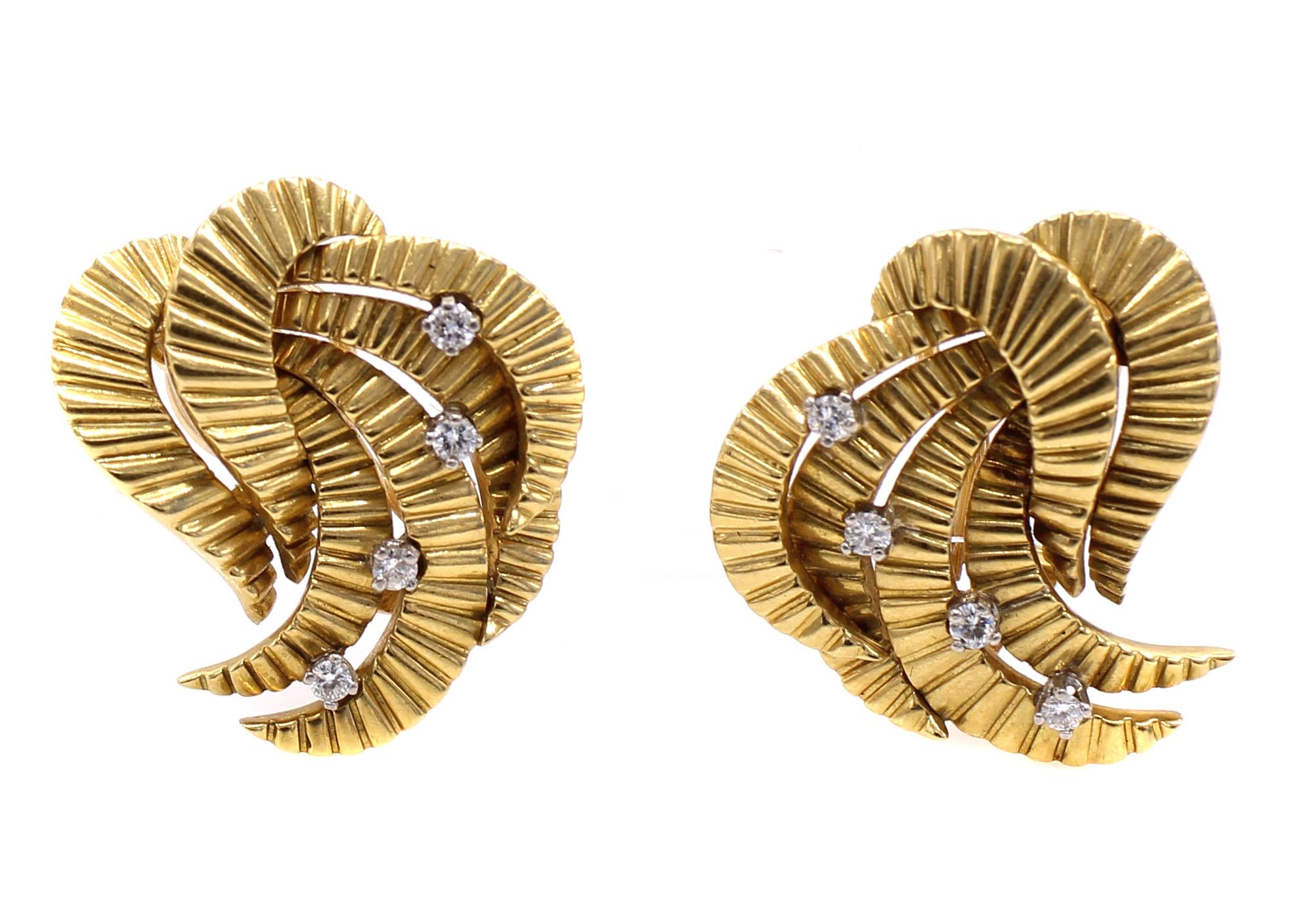 Beautifully designed and masterfully handcrafted 18 karat yellow gold and diamond ear clips from ca 1945. Multiple curved and textured elements with a feather-like design are accentuated with 4 bright white round cut diamonds on each earring. The