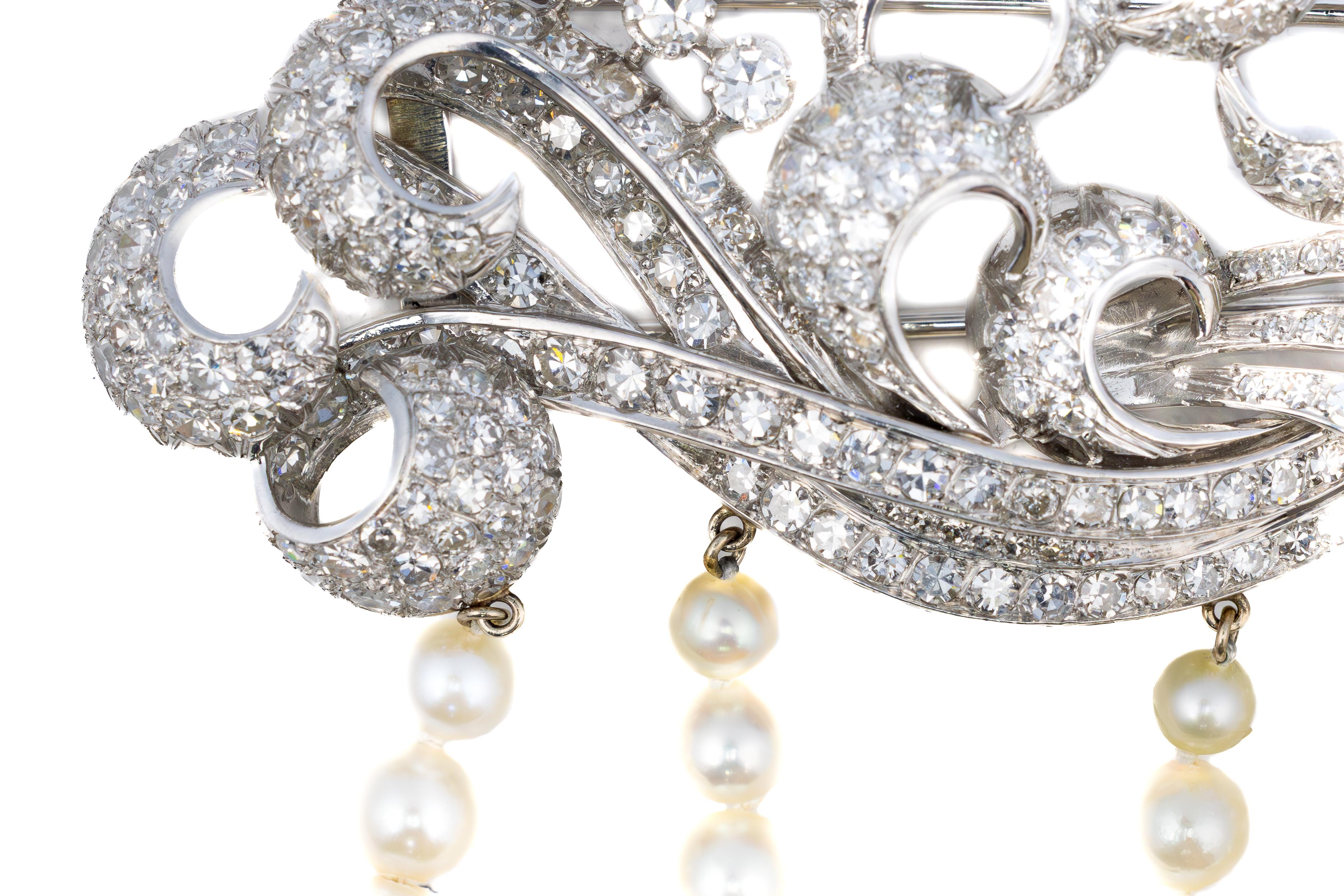 Retro Diamond and Pearl Cascading Brooch

A dazzling Retro-era brooch in platinum, featuring an intricate swirl motif encrusted with sparkling diamonds and enhanced by three gracefully draped strands of lustrous pearls. The brooch’s design evokes