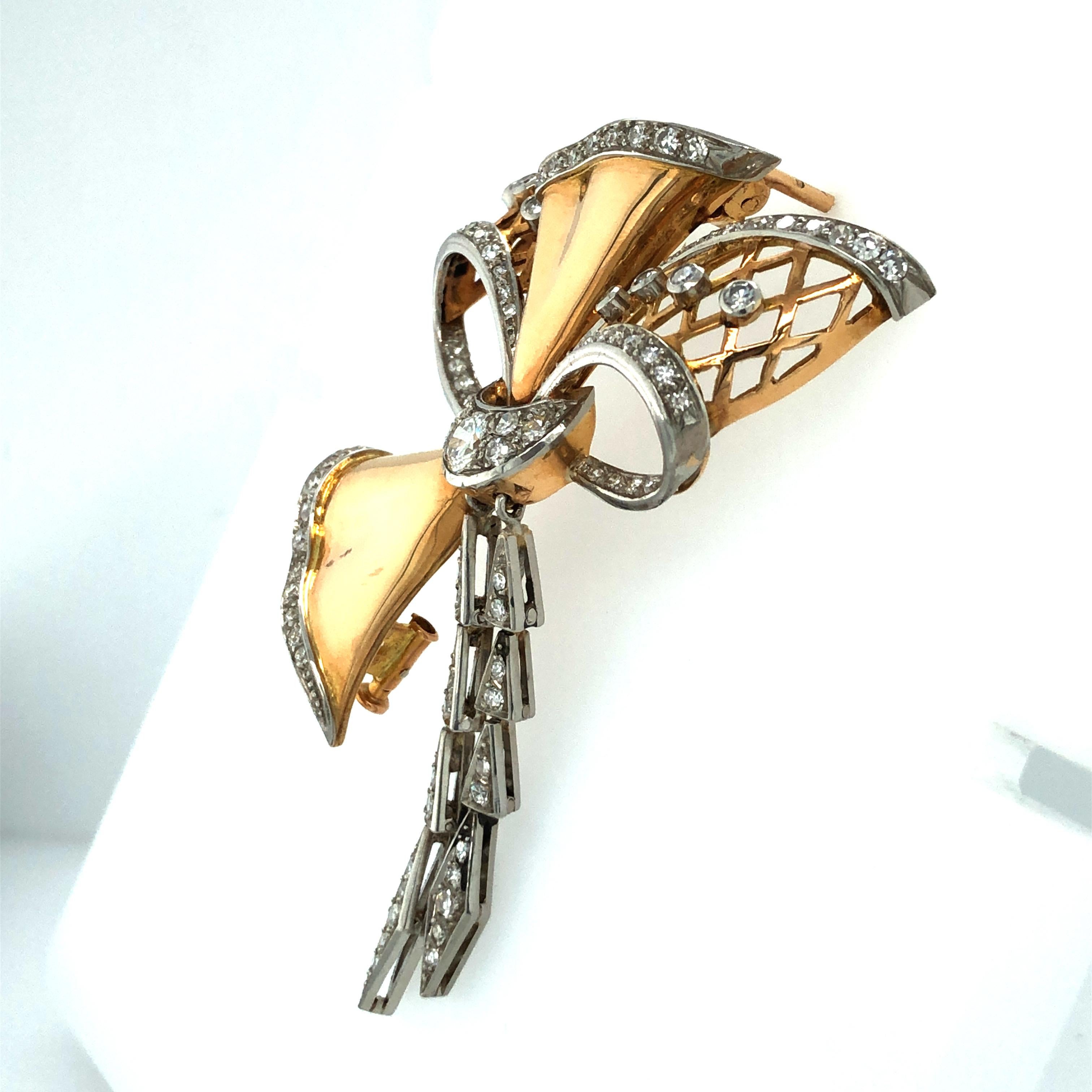 This extravagant yet playful bow brooch from the mid 20th century is crafted in 18 karat rose gold and platinum 950.
The centre part is set with a brilliant-cut diamond of approximately 0.35 carats, H/I colour and vs clarity. In addition, the