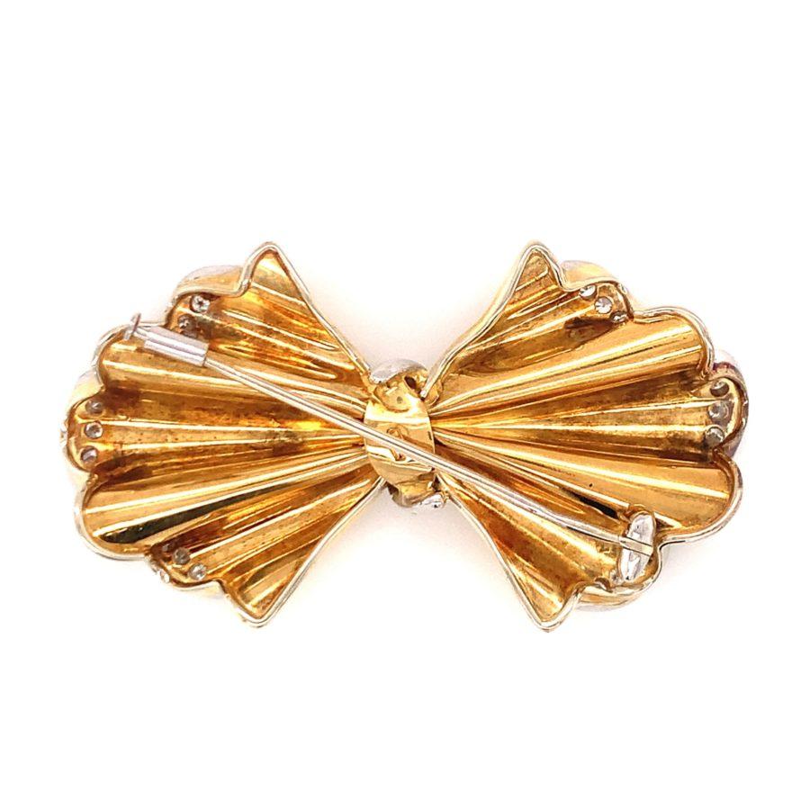 Diese bezaubernde und schicke Retro-Brosche mit Schleifenmotiv aus den 1940er Jahren ist ein wunderschönes Zeugnis der Eleganz und des Flairs dieser Ära. Sie ist aus einer Kombination von 18 Karat Gelb- und Weißgold gefertigt. Die Brosche hat ein