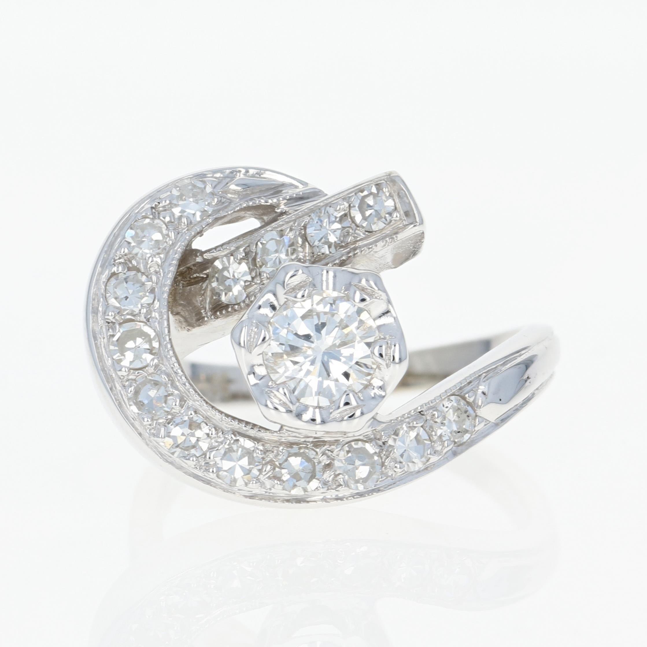 Define your style with this sunning ring! Fashioned in popular 14k white gold, this retro piece from circa 1940’s - 1950’s features a modified bypass-style band adorned in the center with a diamond solitaire. Diamond accents embellish the swirls