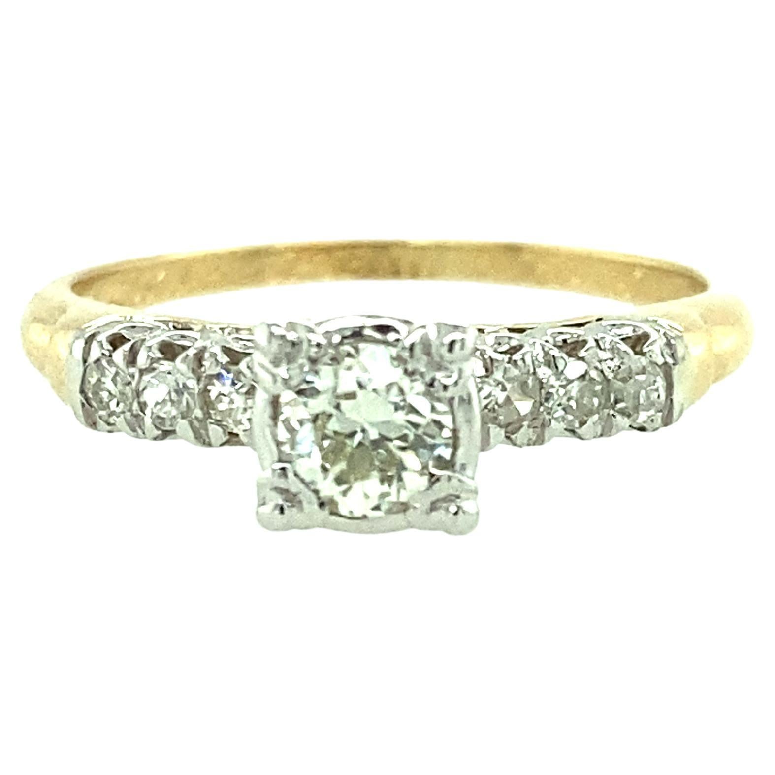 One 14 karat and 18 karat yellow and white gold diamond engagement ring set with one center Old European cut diamond, approximately 0.25 carat total weight, flanked by six single cut diamonds, approximately 0.10 carat total weight with matching H/I