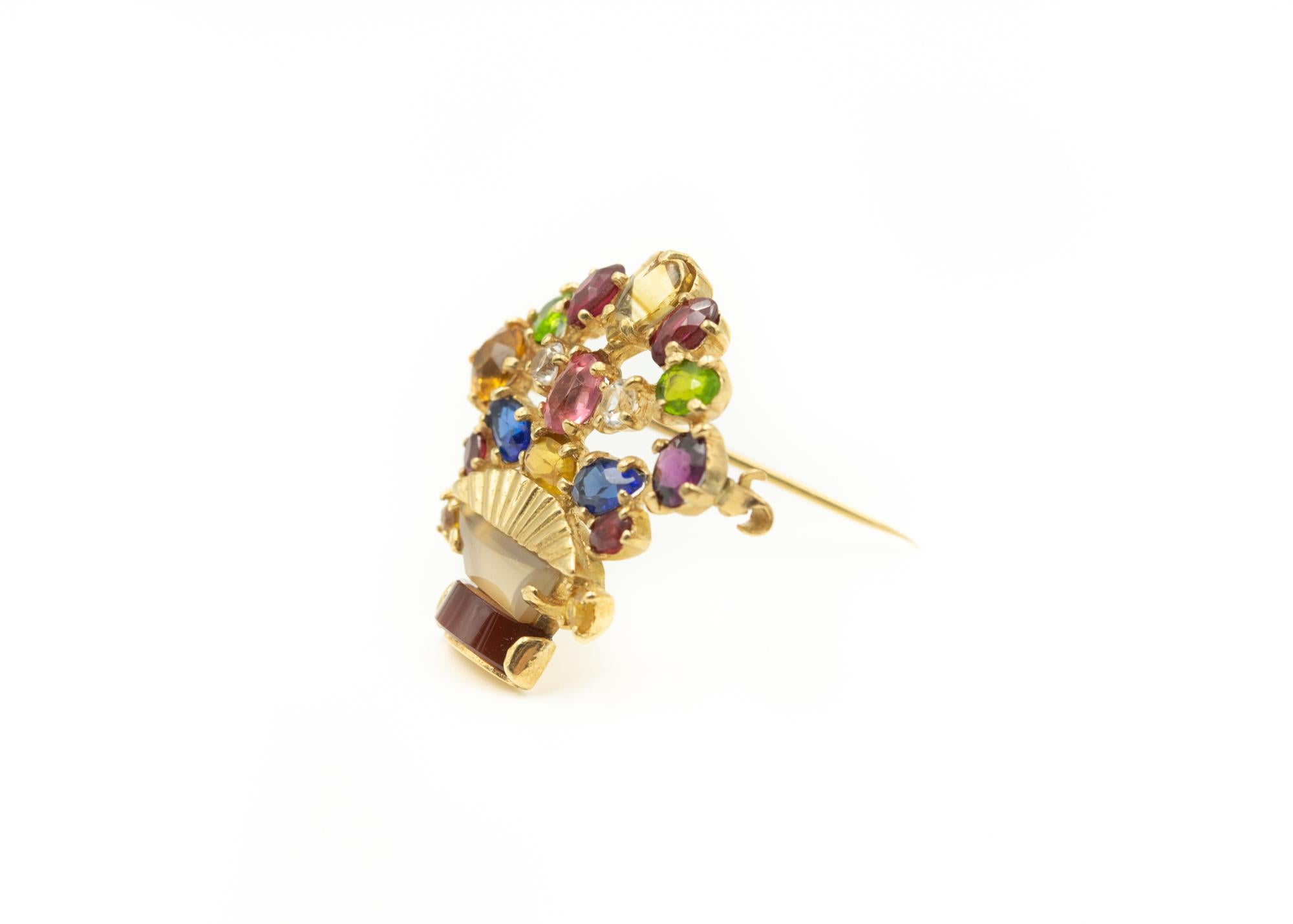Retro (1940s - early 1950s) flower basket brooch featuring a basket made of agate, rock crystal quartz and 14k yellow gold.  The flowers are rubies, sapphires, diamonds, tourmaline, garnet, citrine and peridot.
