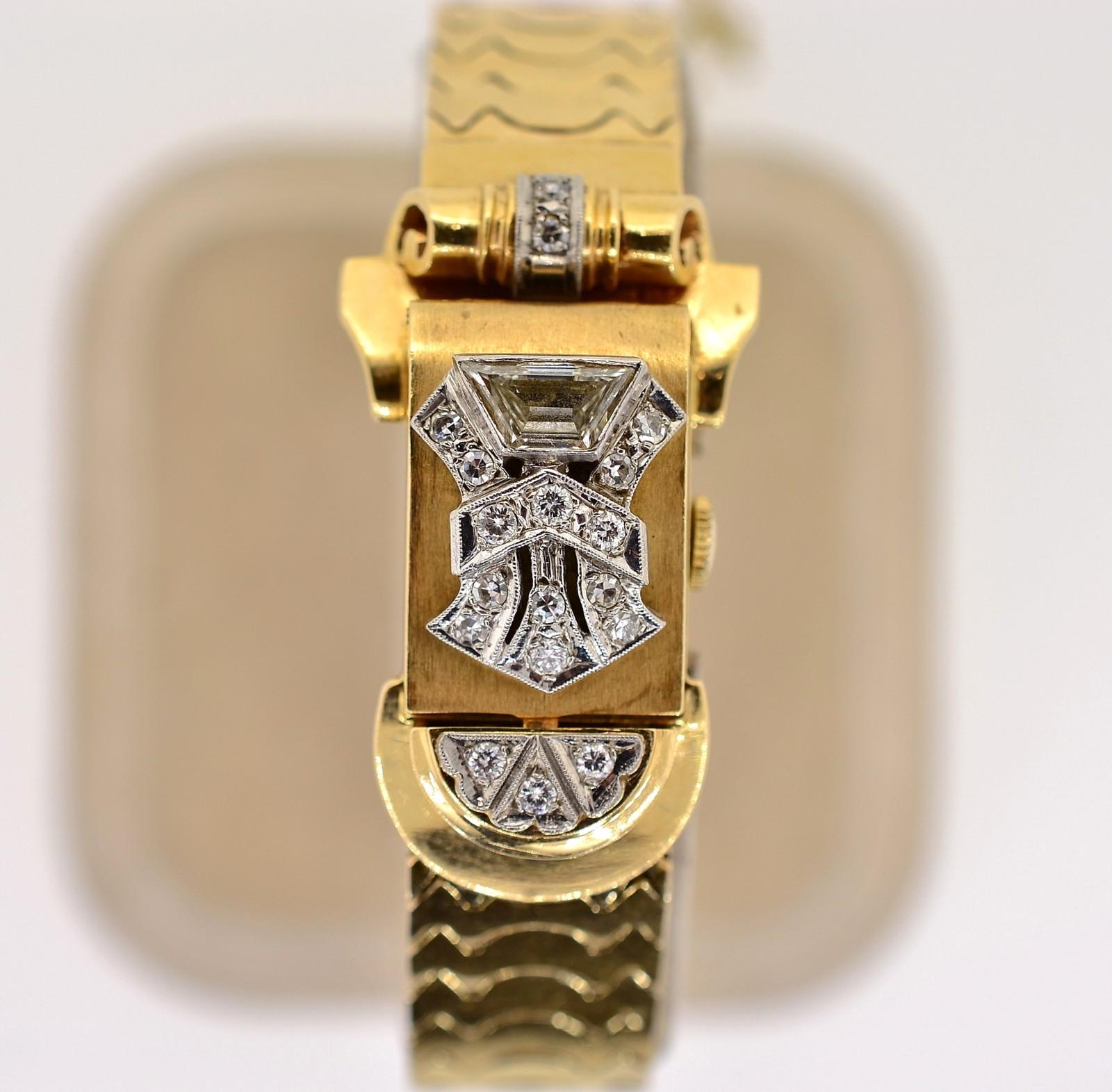 This Retro 1940s beauty was created in 14KT yellwo gold evoking the essence of the era.  The watch itself has a gold over enhanced with a sparkling Trapezoid cut Diamond weighing approx. 0.55 carat of H/I color - VS clarity.  Single cut Diamonds set