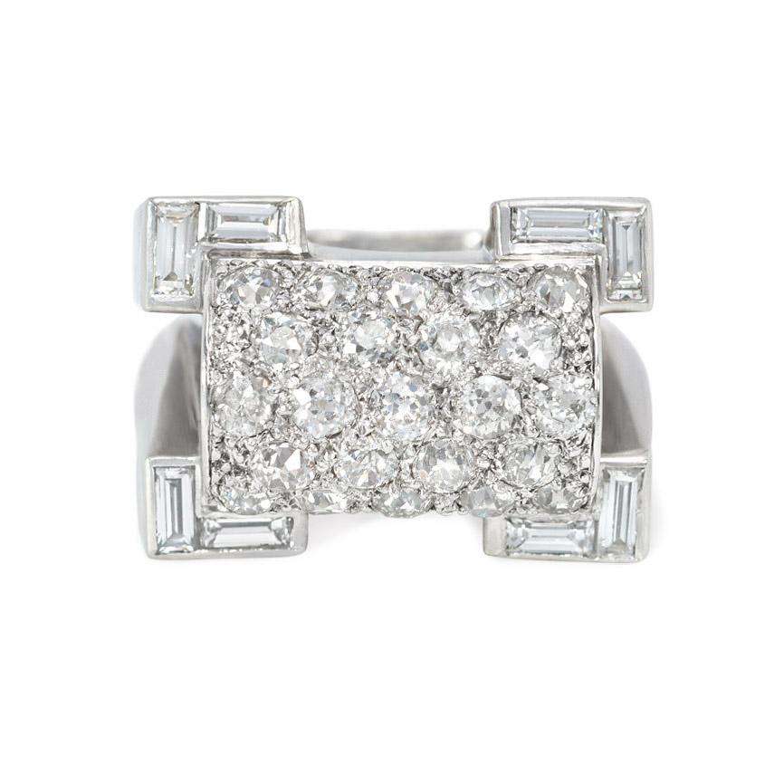 A Retro odeonesque platinum, gold, and diamond ring of geometric design, featuring a pavé diamond-set half-cylindrical center with re-entrant corners set with baguettes, in 18k and platinum.  French import.  Atw 2.94 cts.  Face-up dimensions: 17mm x