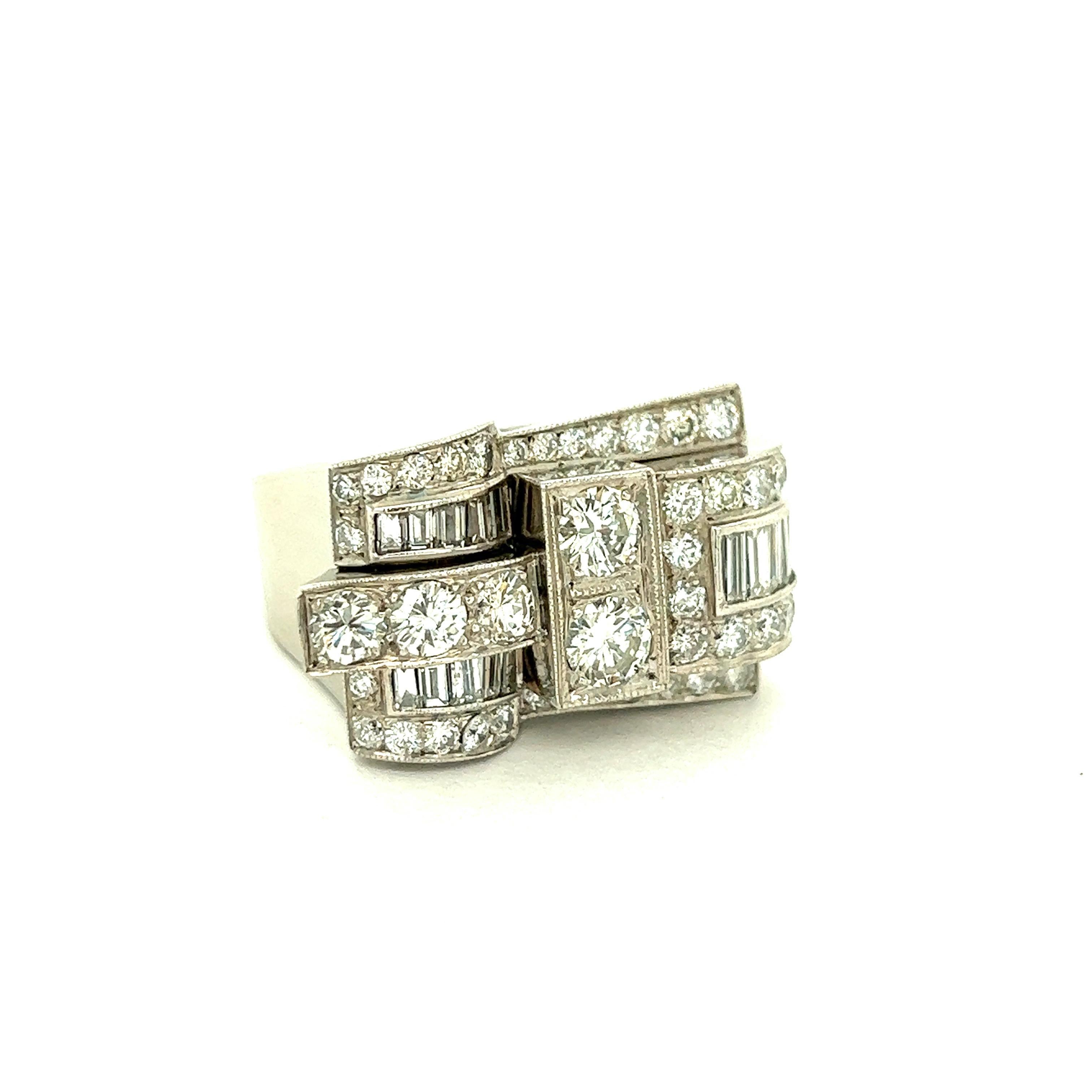 Retro Diamond Platinum Ring

Round- and baguette-cut diamonds of approximately 2.5 carats total, set on platinum metal; marked Plat inside the band

Size: Top width 1.6 cm, length 2.6 cm; 9.25 US
Total weight: 15.8 grams