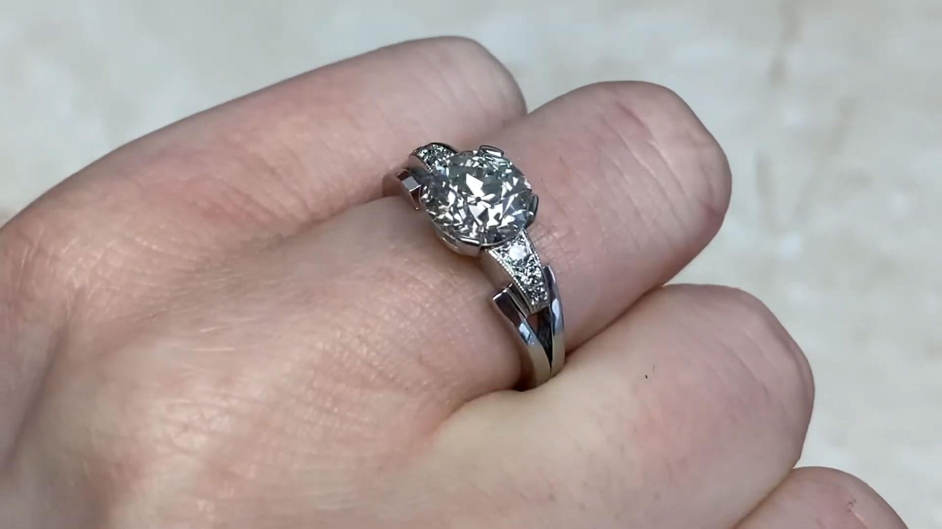 This exquisite Retro-era ring, crafted circa 1945, is a testament to timeless elegance and artistry. At its heart, it showcases a dazzling Approx. 1.9-Carats old European cut diamond, securely set in prongs to highlight its brilliance and classic