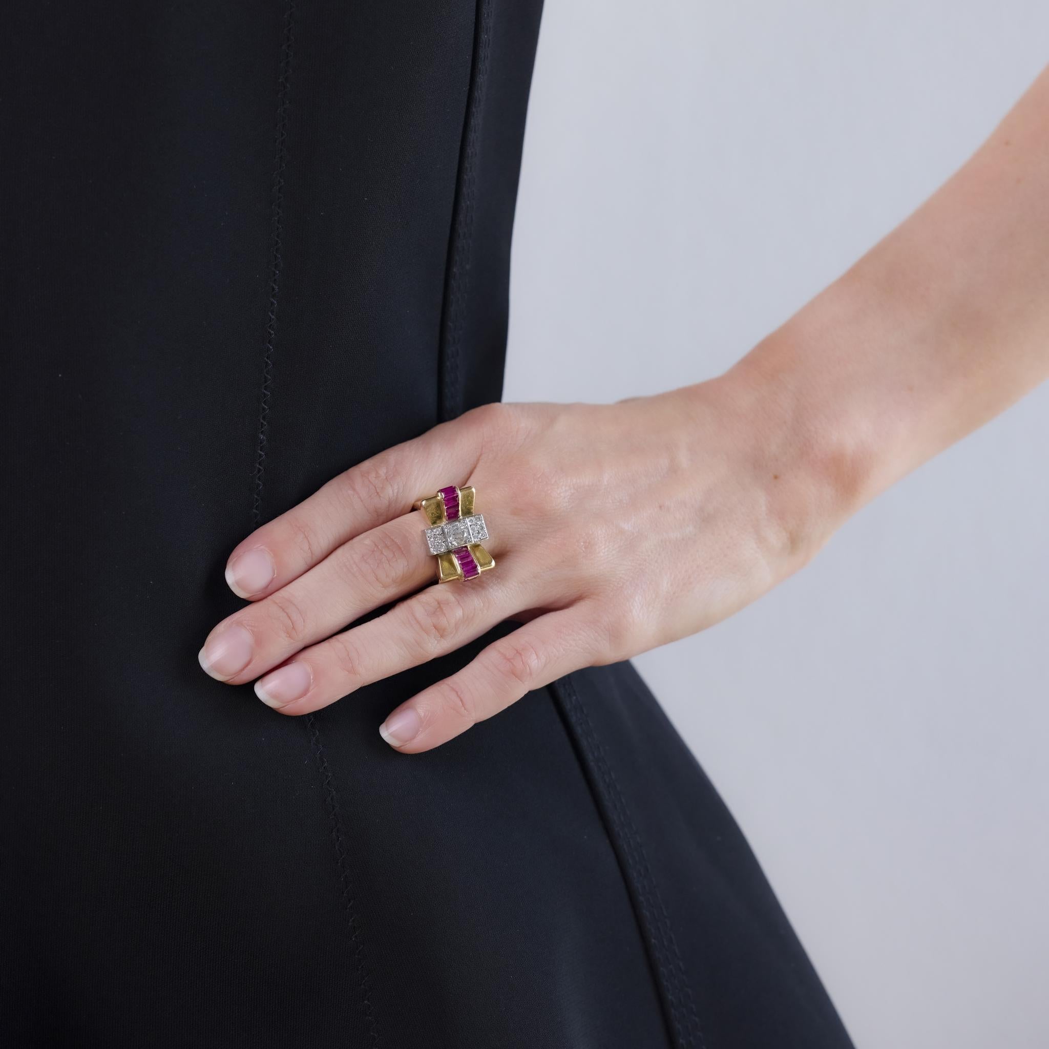 This Retro ring from the 1940s is crafted in 18k yellow gold with platinum accents and features an old European cut diamond weighing approximately 0.65 carats, graded H color and SI clarity. Surrounding the center are twelve round brilliant cut