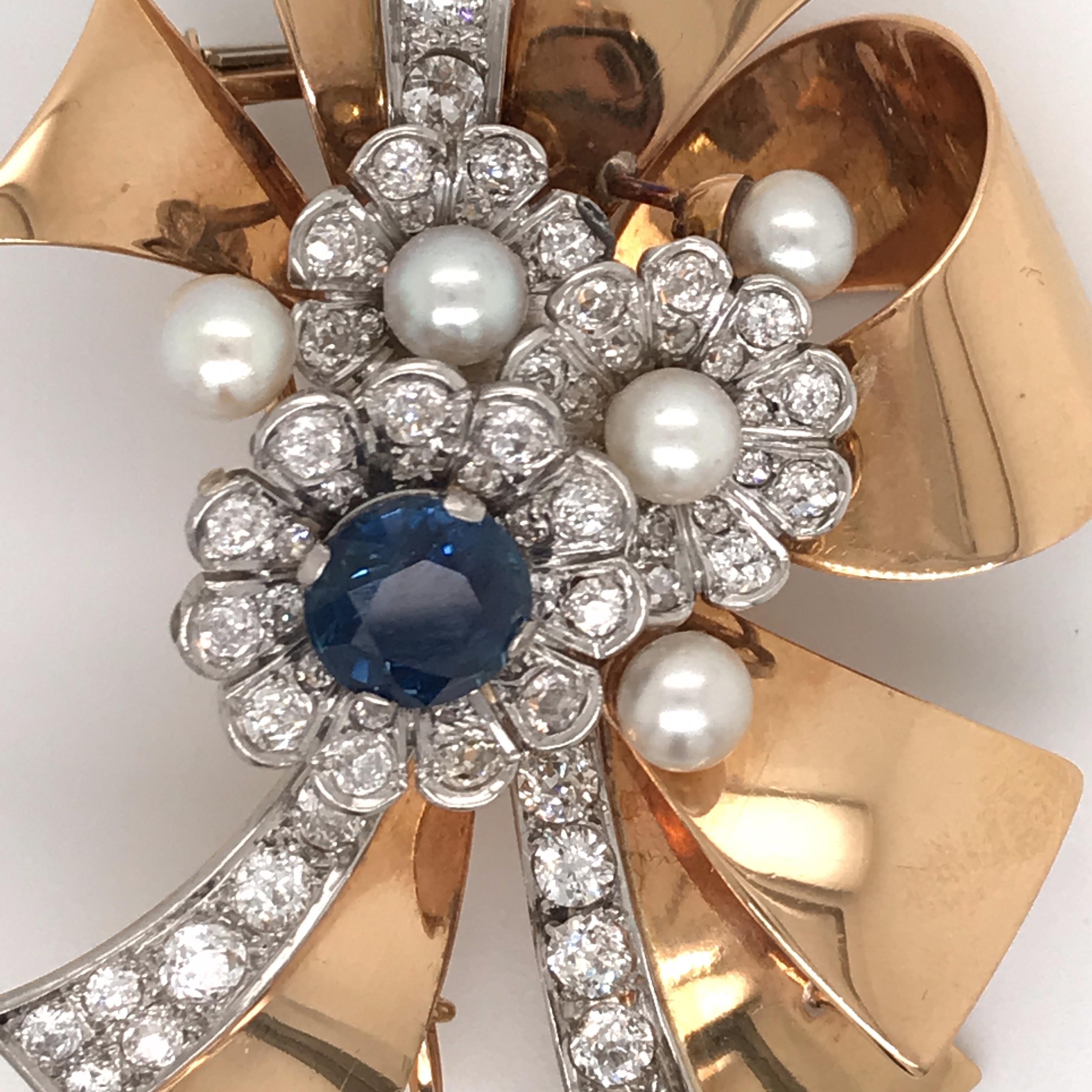 Retro 1950's floral brooch featuring one blue round Sapphire weighing approximately 3.50 carats flanked with numerous round brilliants weighing approximately 5.50 carats with 5 cultural pearls measuring 5.5 mm, 18k yellow gold.