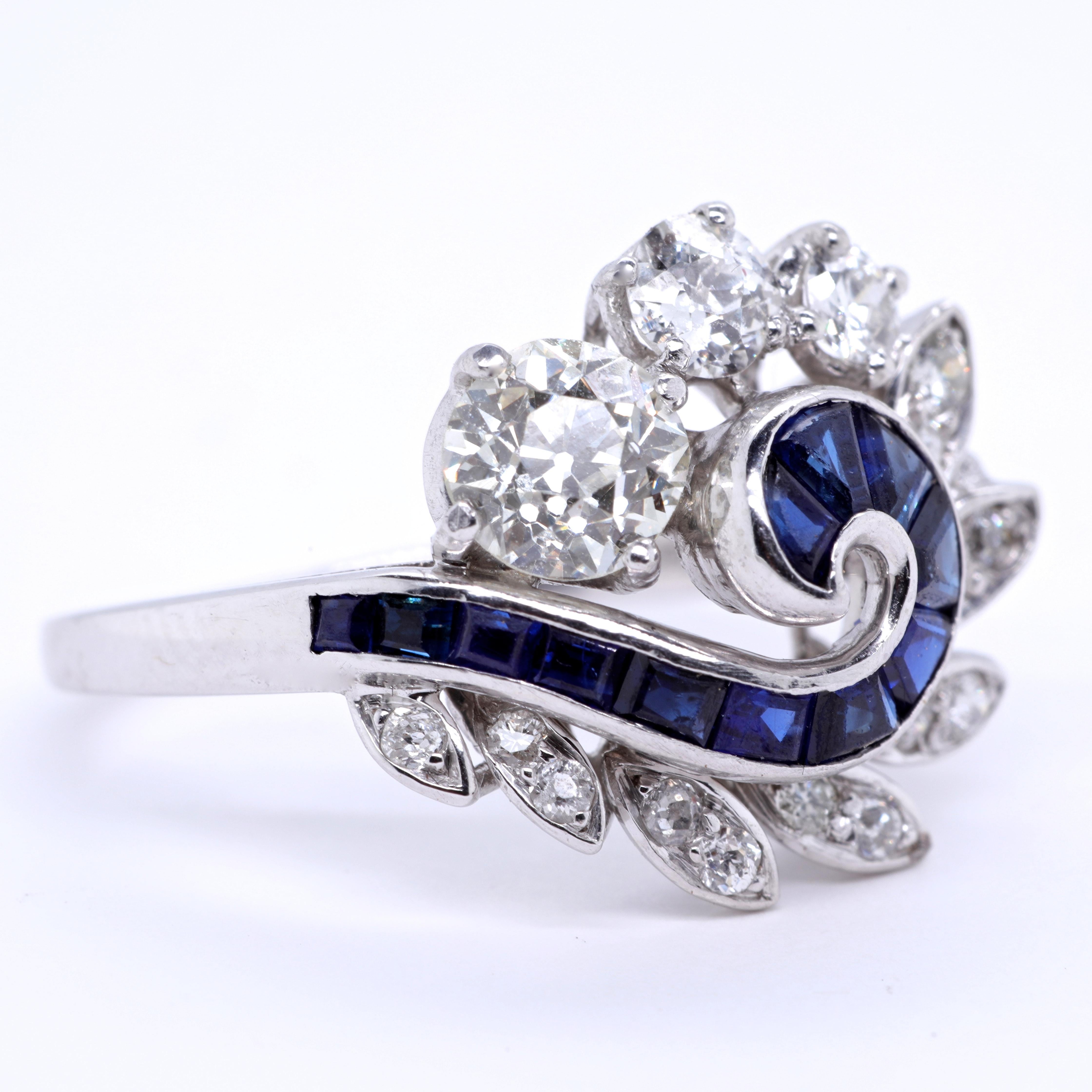 The floral design of this ring attracts the eye with its charm and beauty. Add some color and creativity to your life with this gorgeous Retro Diamond Sapphire Platinum Ring. Accented by old European cut diamonds, approximately 1.00 carat, L-M