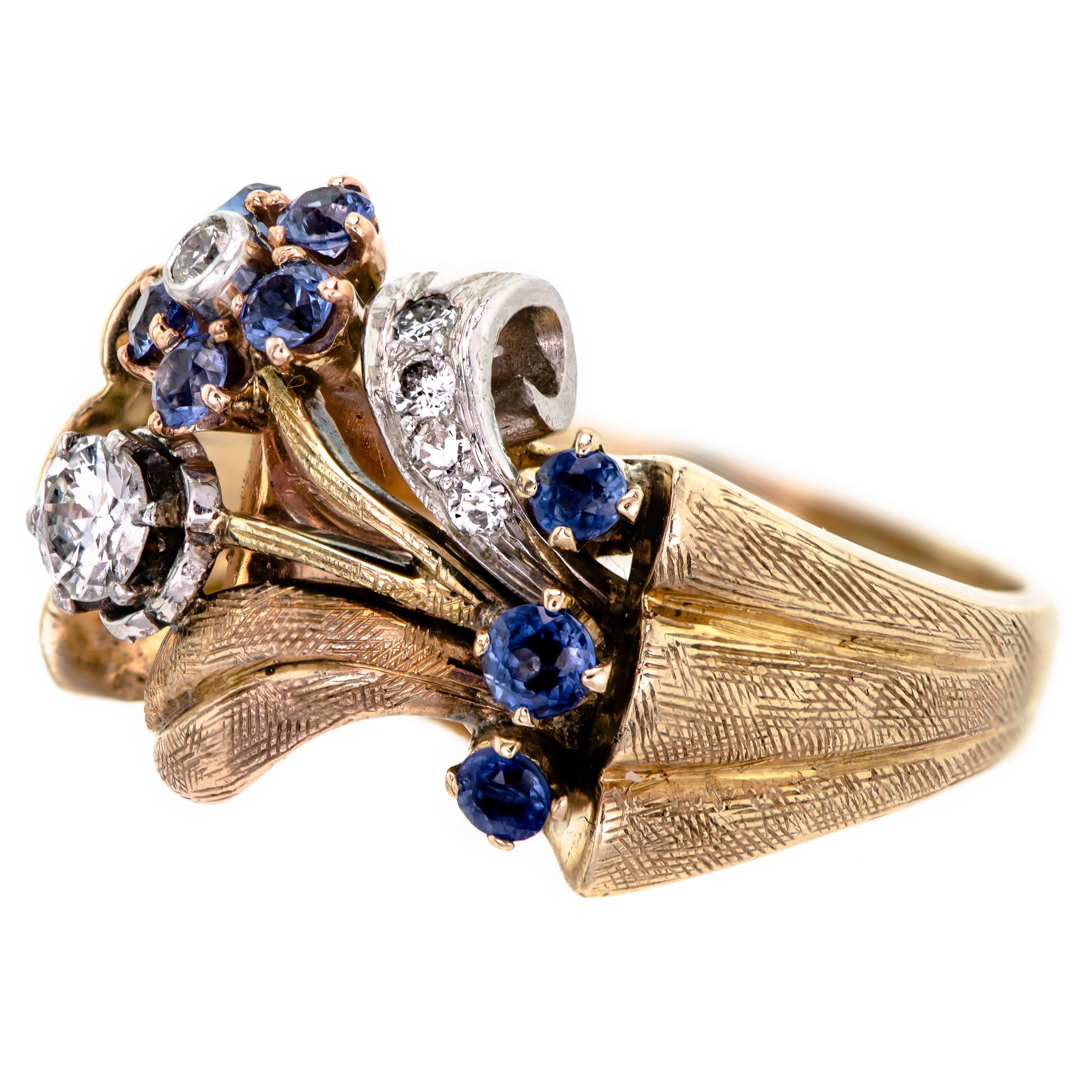 Retro diamond sapphire rose gold and platinum stylized floral bouquet ring set with approx .30 cts tl. wt. of round diamonds further accented with small round mixed cut sapphires into a plat and 14k rose gold ring mount.