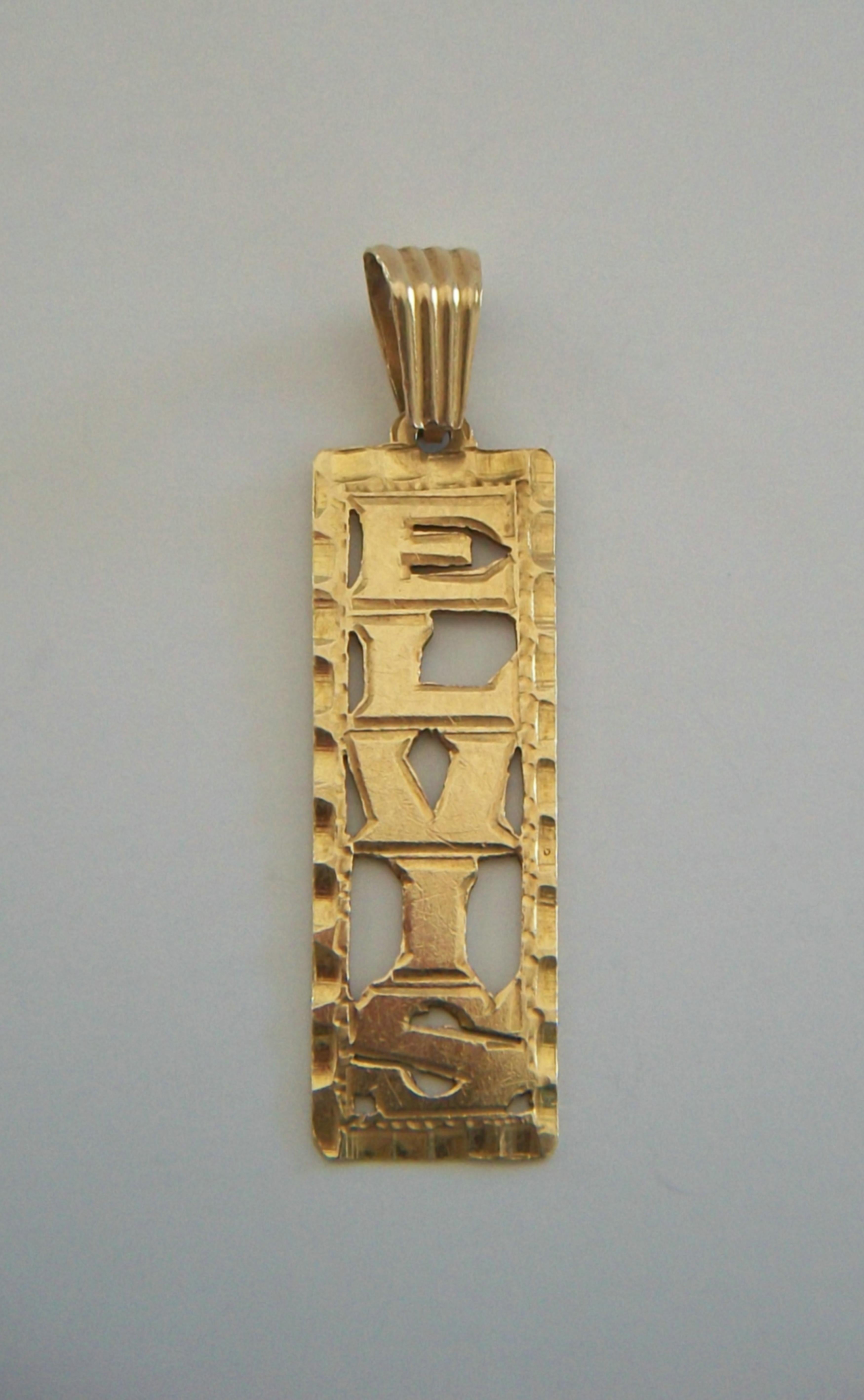 Pendentif de collier rétro Elvis en or jaune 14K - présentant une plaque rectangulaire plate avec le fond autour de chaque lettre poinçonné et limé - motif martelé en forme de vague sur les quatre bords - dos poli uni - grande anse - marqué 14K au