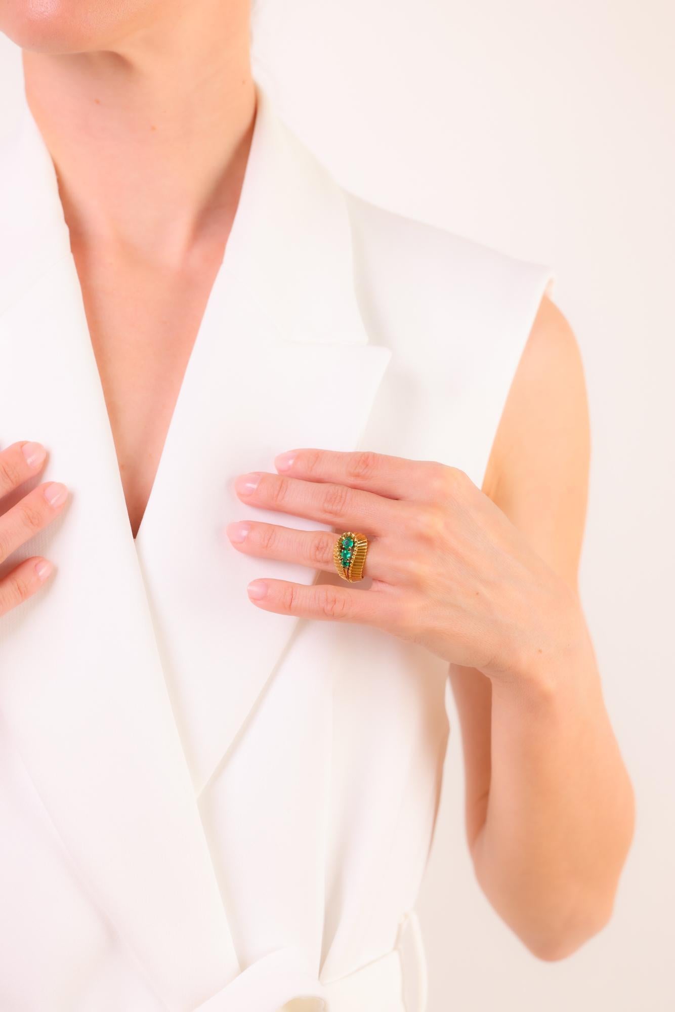 Dieser Ring aus 18-karätigem Gelbgold im Retro-Stil präsentiert drei leuchtende Smaragde, die zeitlose Eleganz und Vintage-Charme aus den 1940er Jahren versprühen.

Mittelstein: 3 runde Smaragde im Brillantschliff
Gewicht: Ungefähr .70 Karat
Metall: