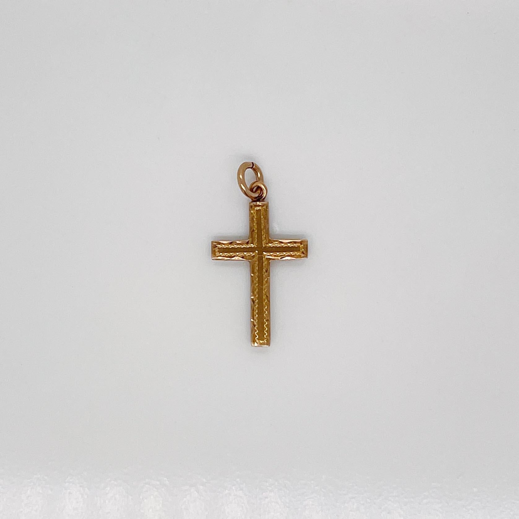 Un très beau petit pendentif en forme de croix.

En or jaune 10 carats. 

Avec une décoration brite sur le devant. 

Sertie d'une boucle pour être attachée à un collier ou un bracelet.

Dans l'ensemble, tout simplement une merveilleuse breloque