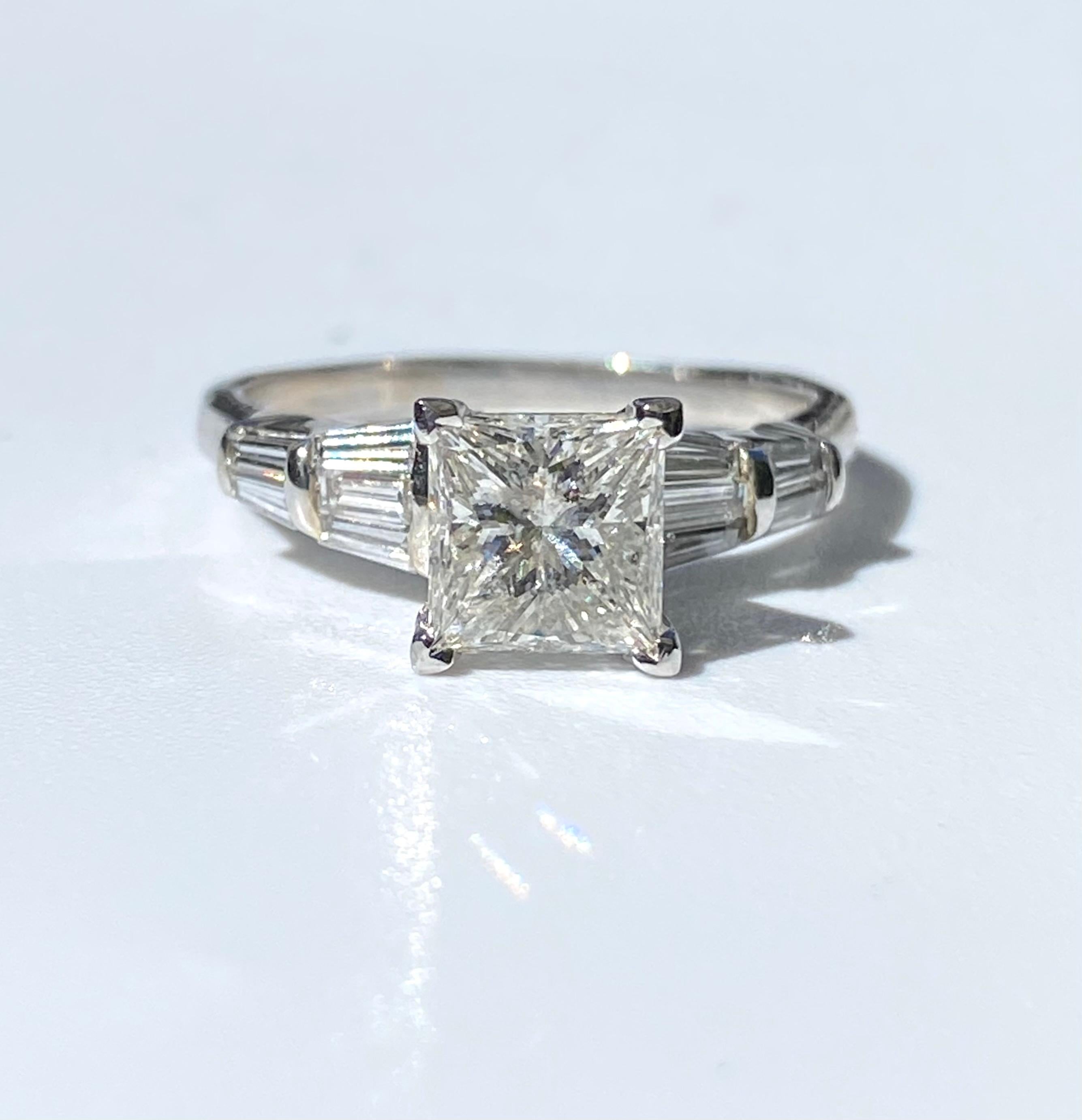 Lovely vintage diamond engagement ring centering a roughly 1.60 Carat Princess-Cut Diamonds, shouldered by 10 Princess-Cut Diamonds totaling 0.60 carats, and set in 14K Yellow Gold. 

Details:
✔ Stone: Diamond
✔ Center-Stone Weight: 1.60 Carats
✔
