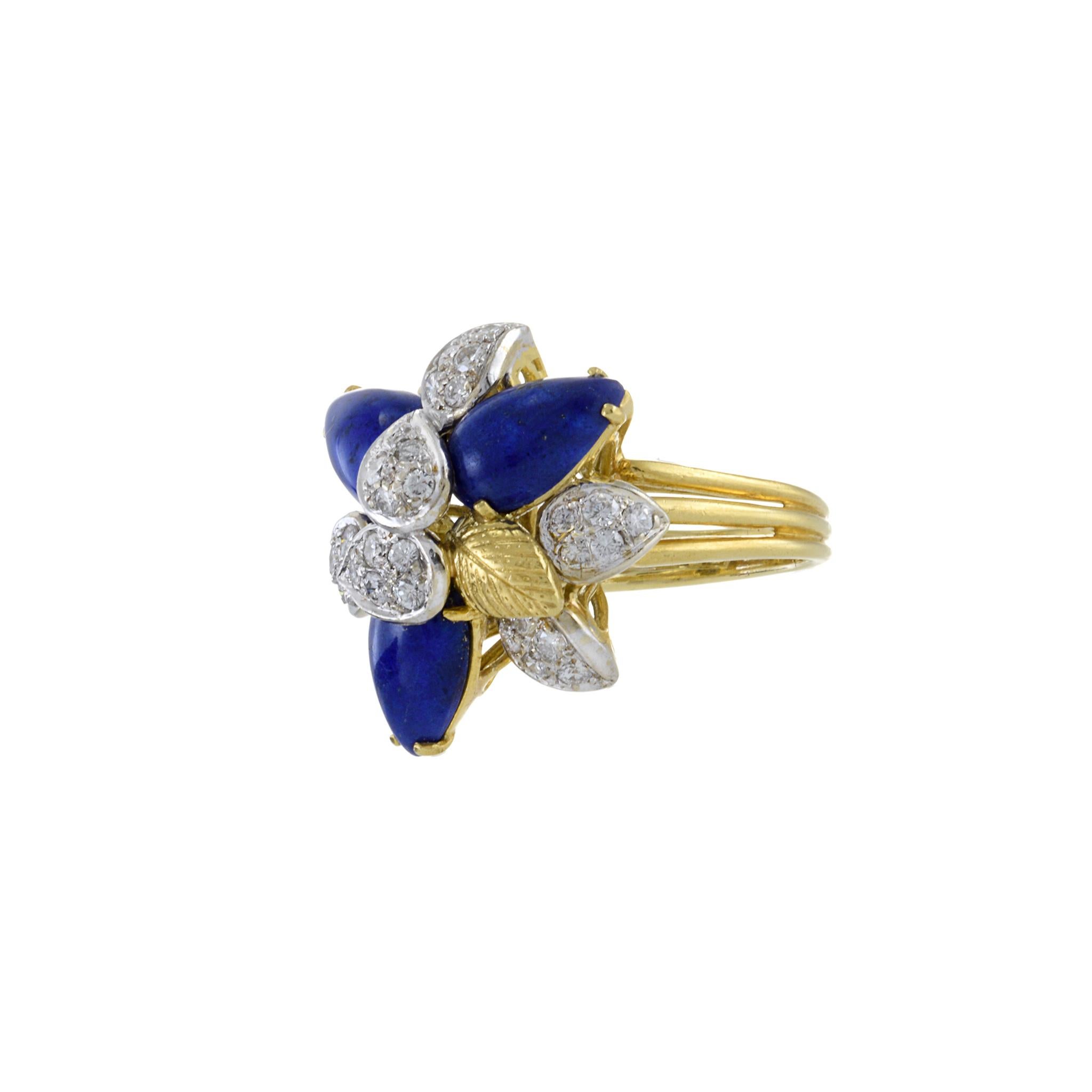 The Estate Retro Era 18KT Yellow Gold Lapis Lazuli and Diamond Flower Ring is a dazzling embodiment of vintage charm and elegance. This exquisite piece beautifully marries the deep, celestial blue of lapis lazuli gemstones with the radiant