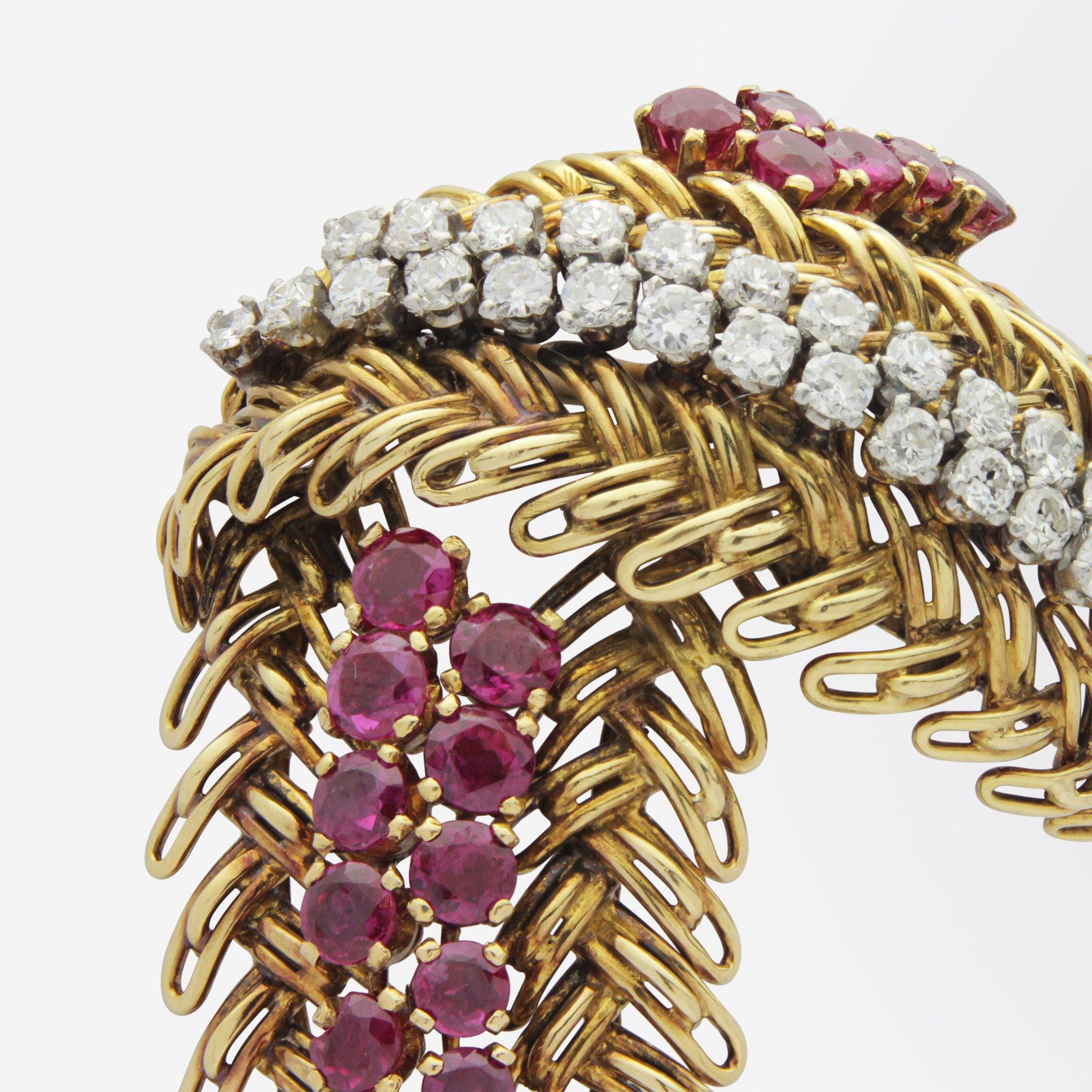 The most wonderful 18 karat yellow gold, ruby and diamond spray brooch from the 1950s. The handcrafted cocktail brooch appears as stylised feathers which have been accented with spines of brilliant cut rubies and semi modern brilliant cut diamonds.