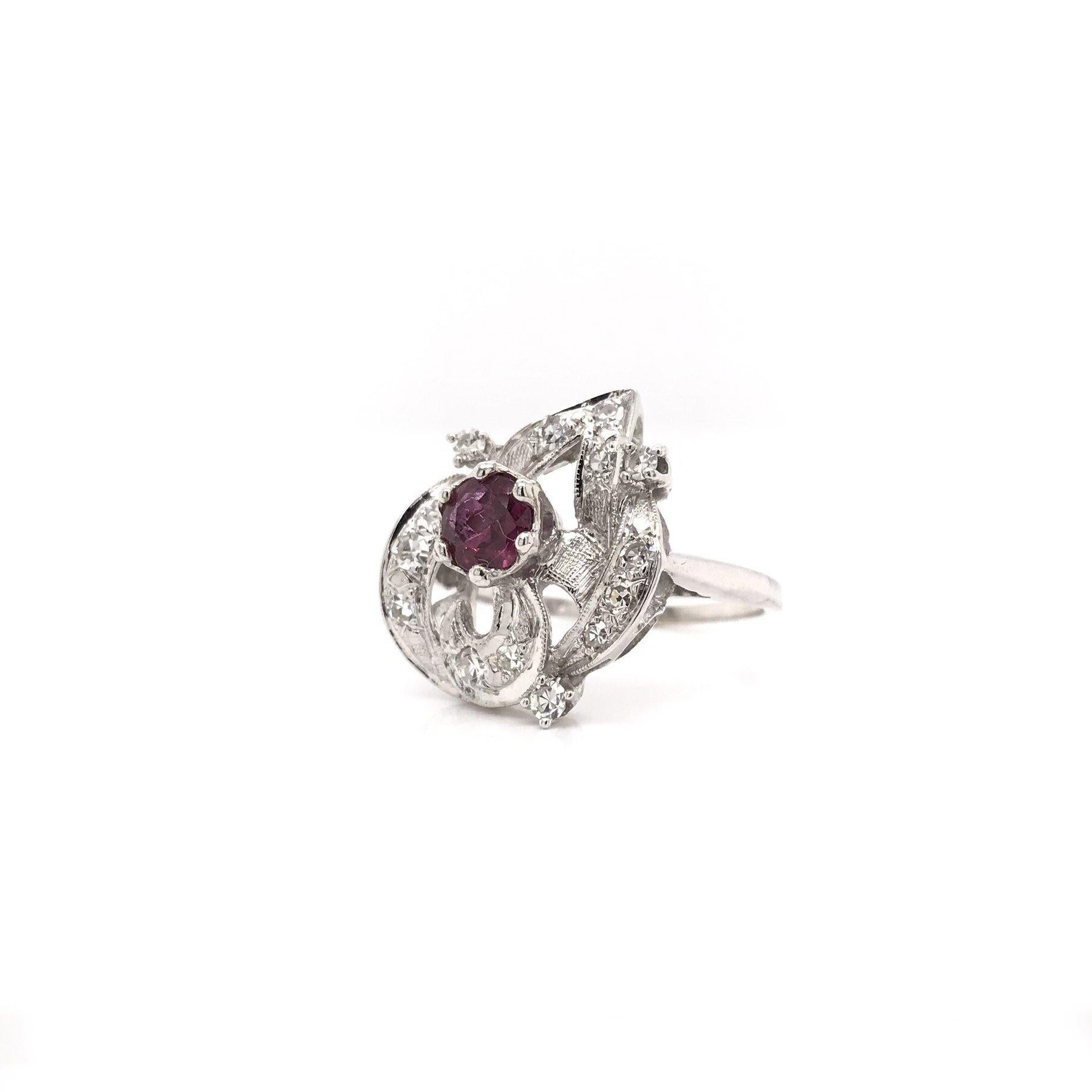This ruby and diamond ring was crafted sometime during the Retro design era ( 1940-1960 ) and it shows! During this grand era of jewelry design you see a lot of diamonds, rubies, and unique cluster arrangements utilized. This bold cocktail design is
