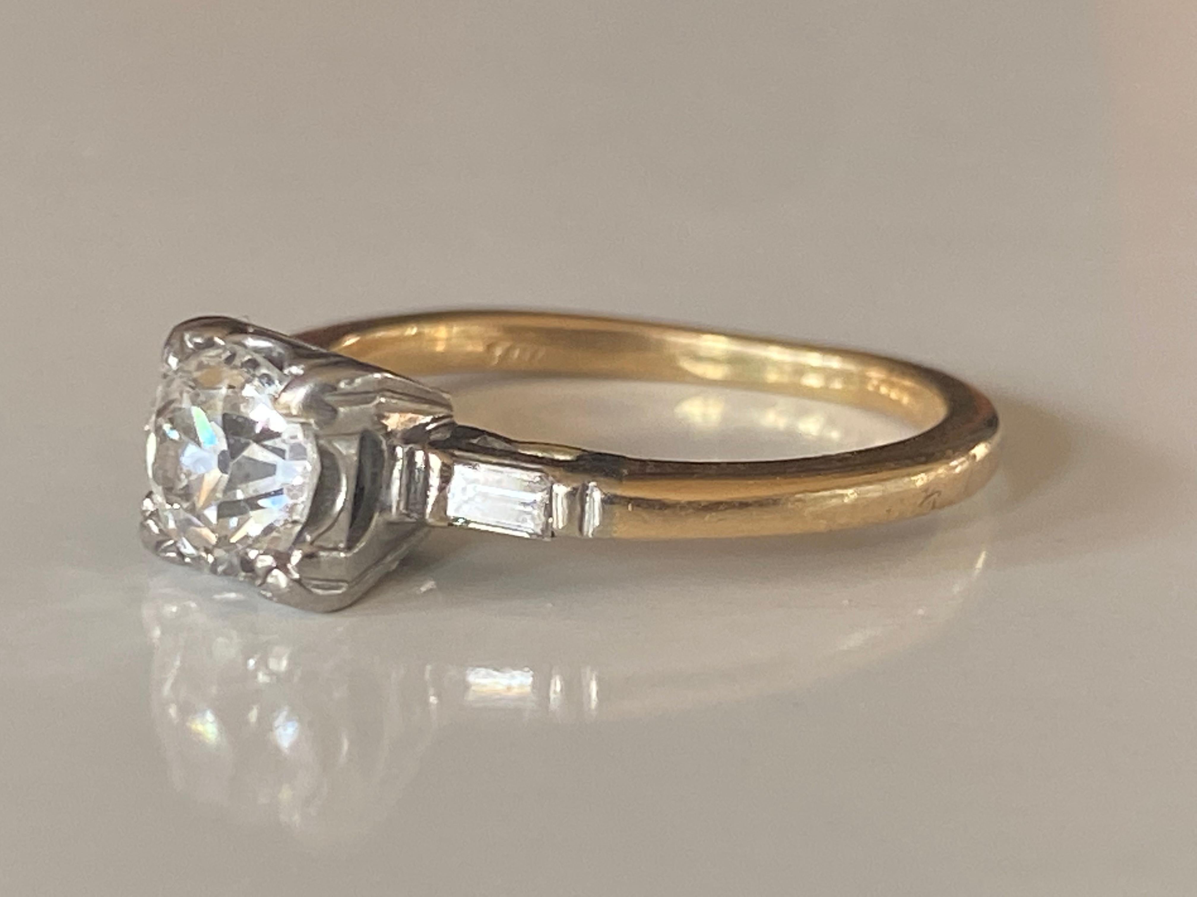 This stunning two-tone ring set in 14kt yellow and white gold is designed around an Old European cut diamond center stone measuring approximately 1.00 carat, G color, SI2 clarity and complemented by two baguette diamond side stones totaling