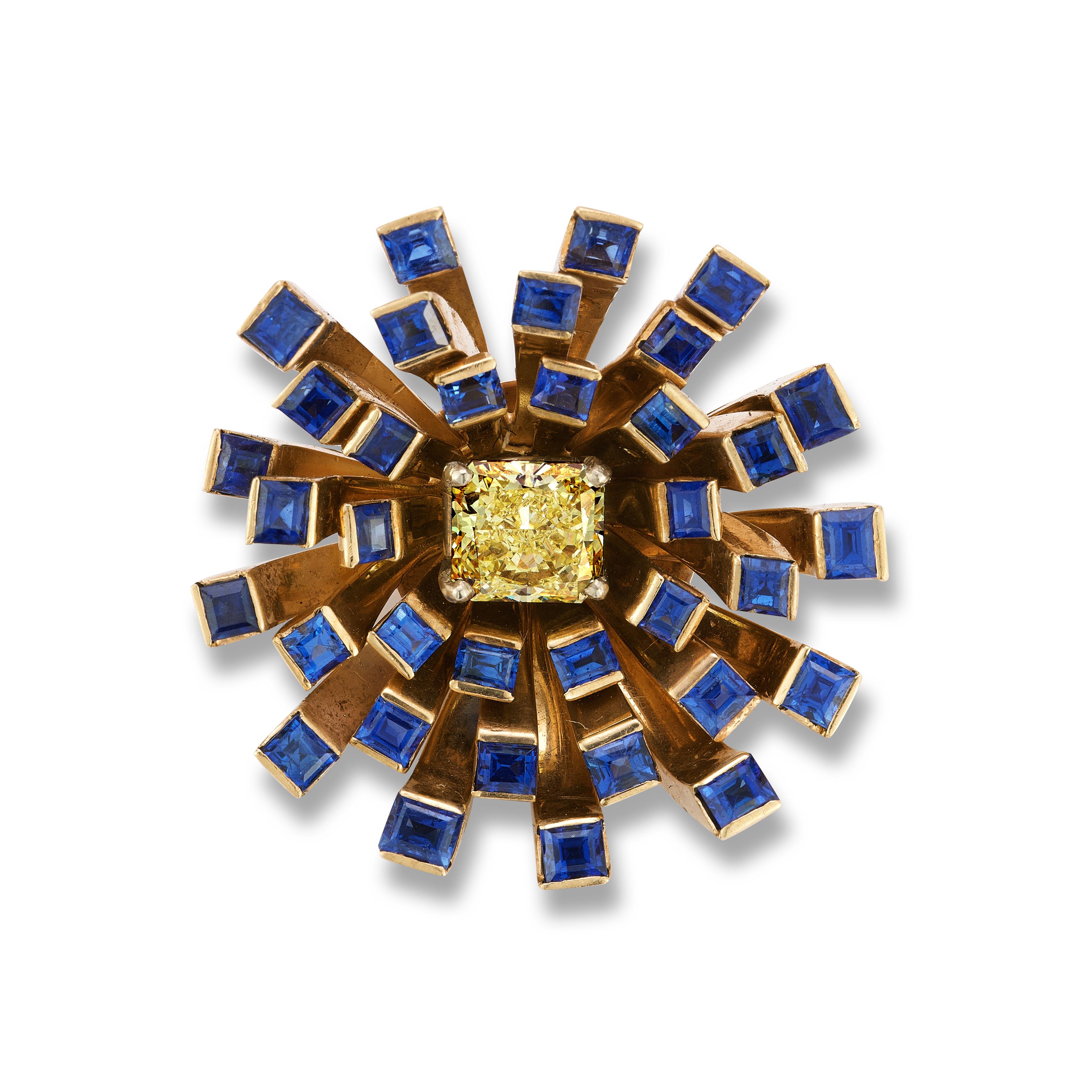 Broche rétro fantaisie fleur en diamant jaune et saphir 

Broche représentant un  Diamant jaune fantaisie certifié GIA entouré de saphirs dessinant un motif floral.

Dimensions : 1