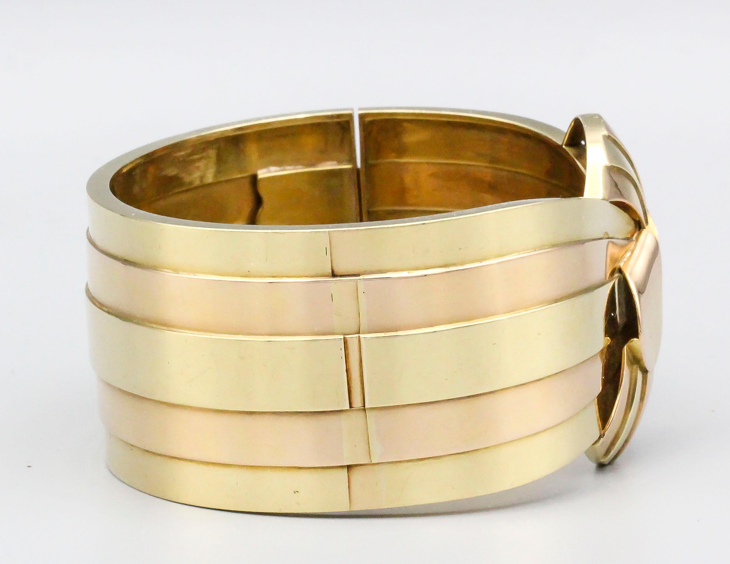 Fine 18k yellow and rose gold bangle bracelet, of French origin and circa 1940s.  Weighing over 100 grams, the bracelet is of substantial heft, and over 1.5 inch at its widest point.  Will comfortably fit a wrist size of 7-7.25 in circumference,