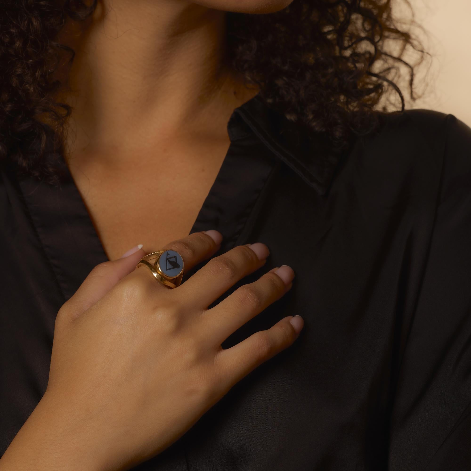 Este atrevido anillo de la era retro de los años 40 presenta una pieza central de piedra dura bellamente tallada, rica en textura y detalles. Engarzado en luminoso oro amarillo de 18 quilates, el diseño rezuma fuerza vintage y presencia escultural.