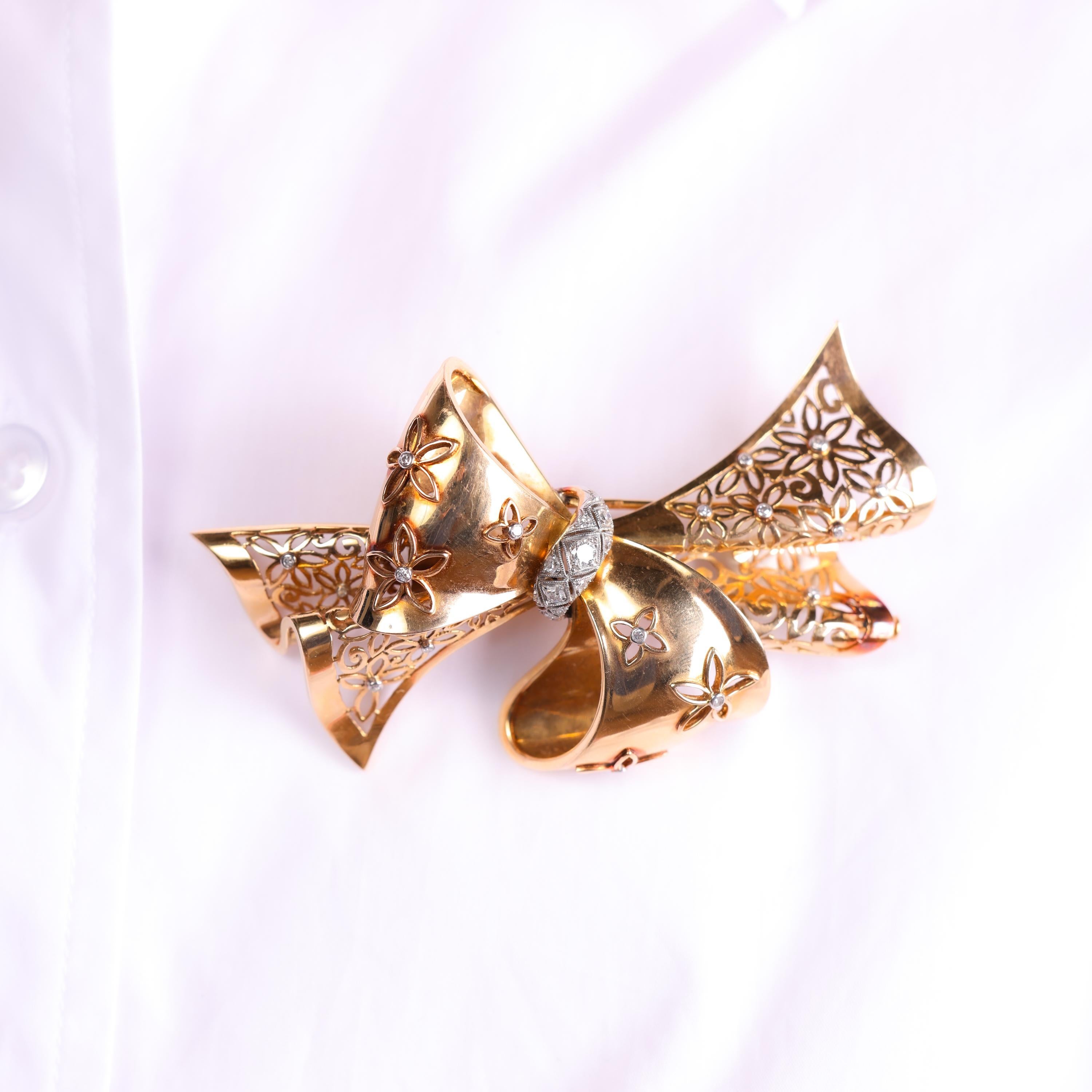 This Retro French ribbon brooch features dazzling diamonds set in 18k yellow gold and platinum, embodying elegance and bold design from the 1940s.

Center stone: 33 old European and single cut diamonds 
Weight: Approximately .50 carats
Color:
