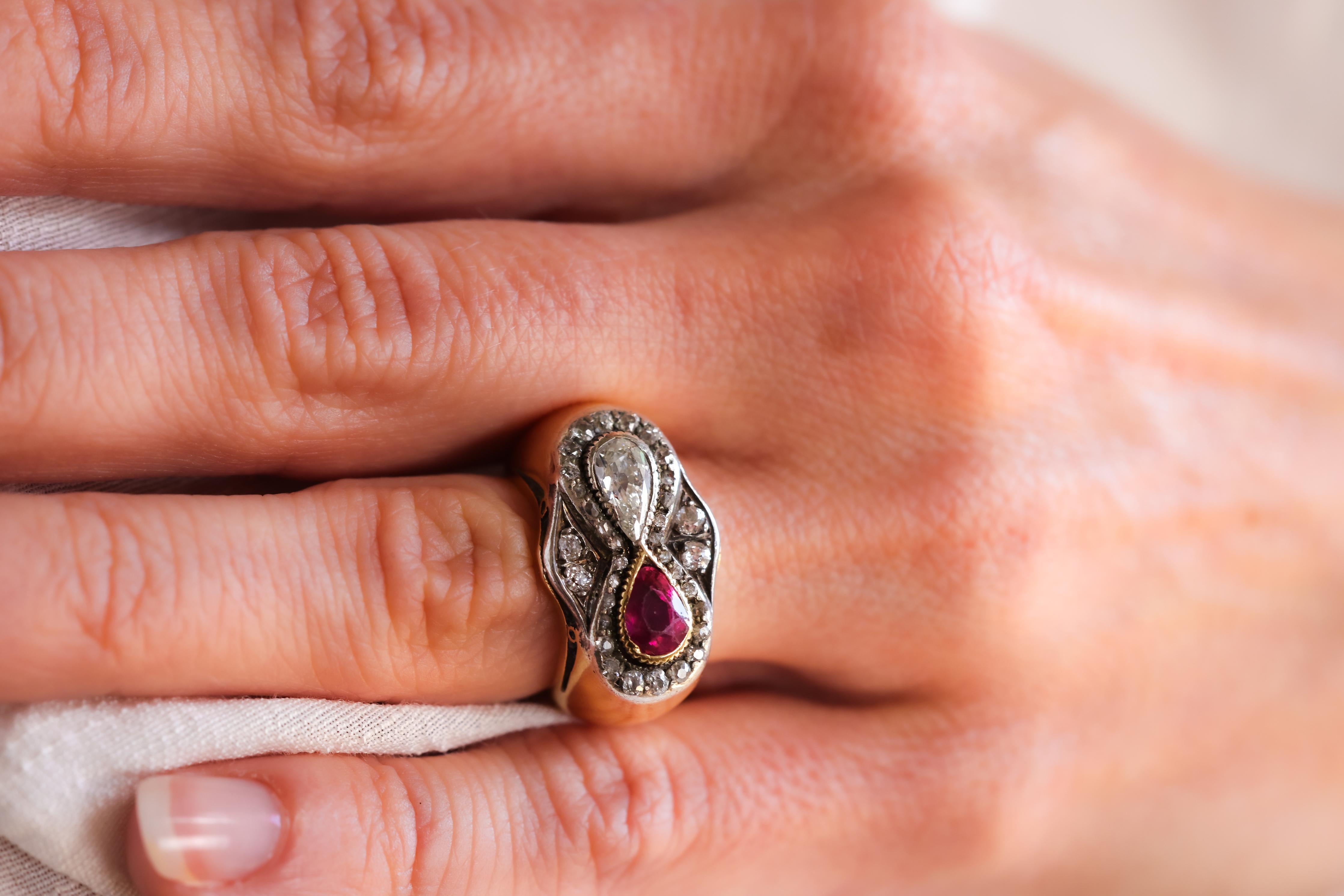 Mittelstein: Rubin
Schnitt: Birne
Gewicht: Ungefähr 1,00 Karat
Farbe: Rot
Akzent-Stein: Diamant
Schliff: Antike Birne
Gewicht: Ungefähr 0,70 Karat
Farbe: H
Klarheit: SI
Akzentuierungsstein: 34 Diamanten
Schnitt: Rose, Single und Old