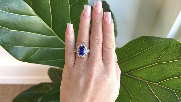 One Retro French Tanzanite Diamond 18 Karat Gold Cluster Ring. Featuring one oval tanzanite weighting approximately 6.00 carats. Accented by two old European cut diamonds with a total weight of approximately 0.90 carat, graded H color, VS clarity,