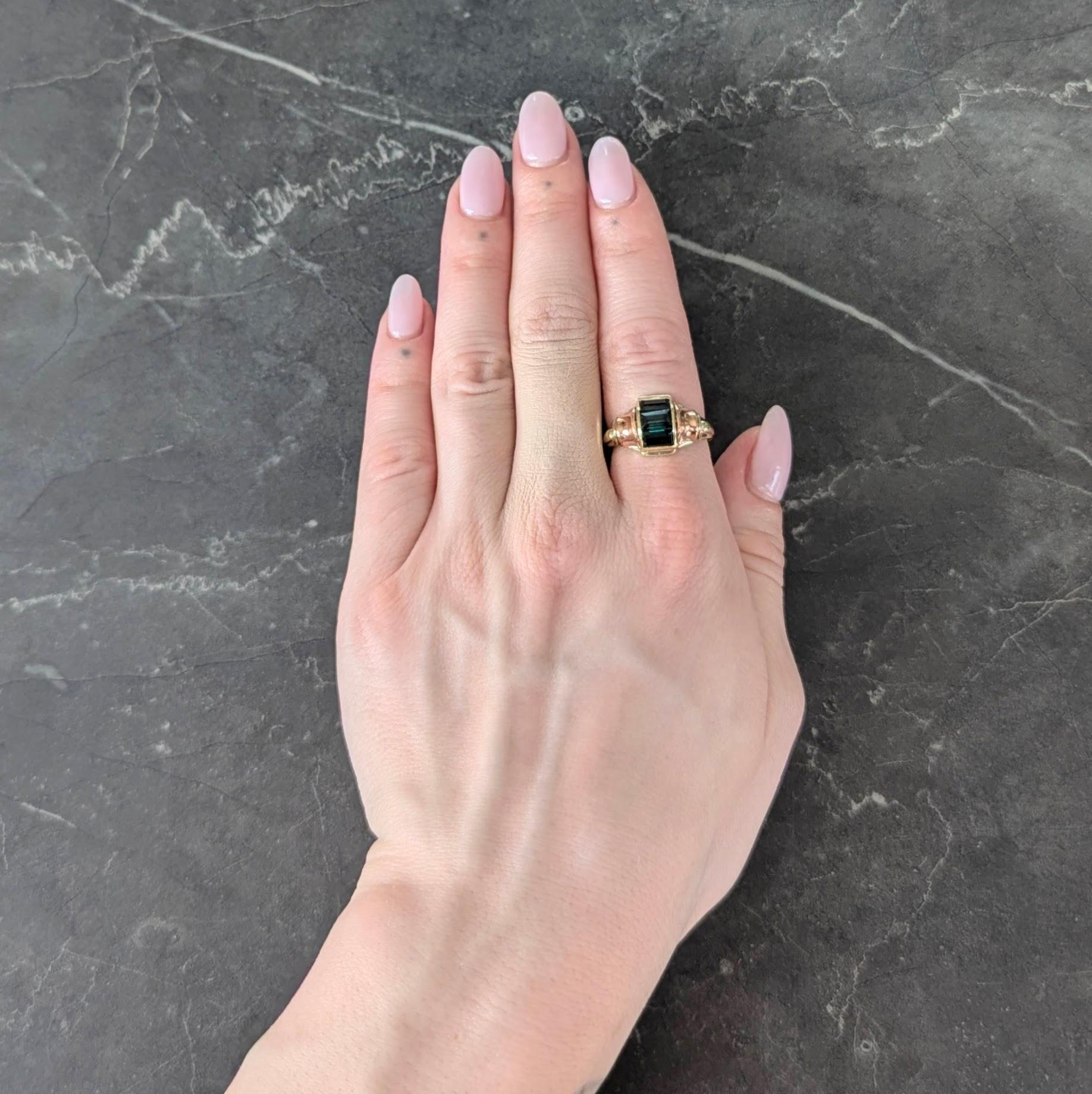 Designed as a domed yellow gold form centering an arching channel set with tourmalines
Transparent green in color with dark saturation and baguette cut
Flanked by flaring concave rose gold shoulders
Completed by grooved yellow gold shank
With a high