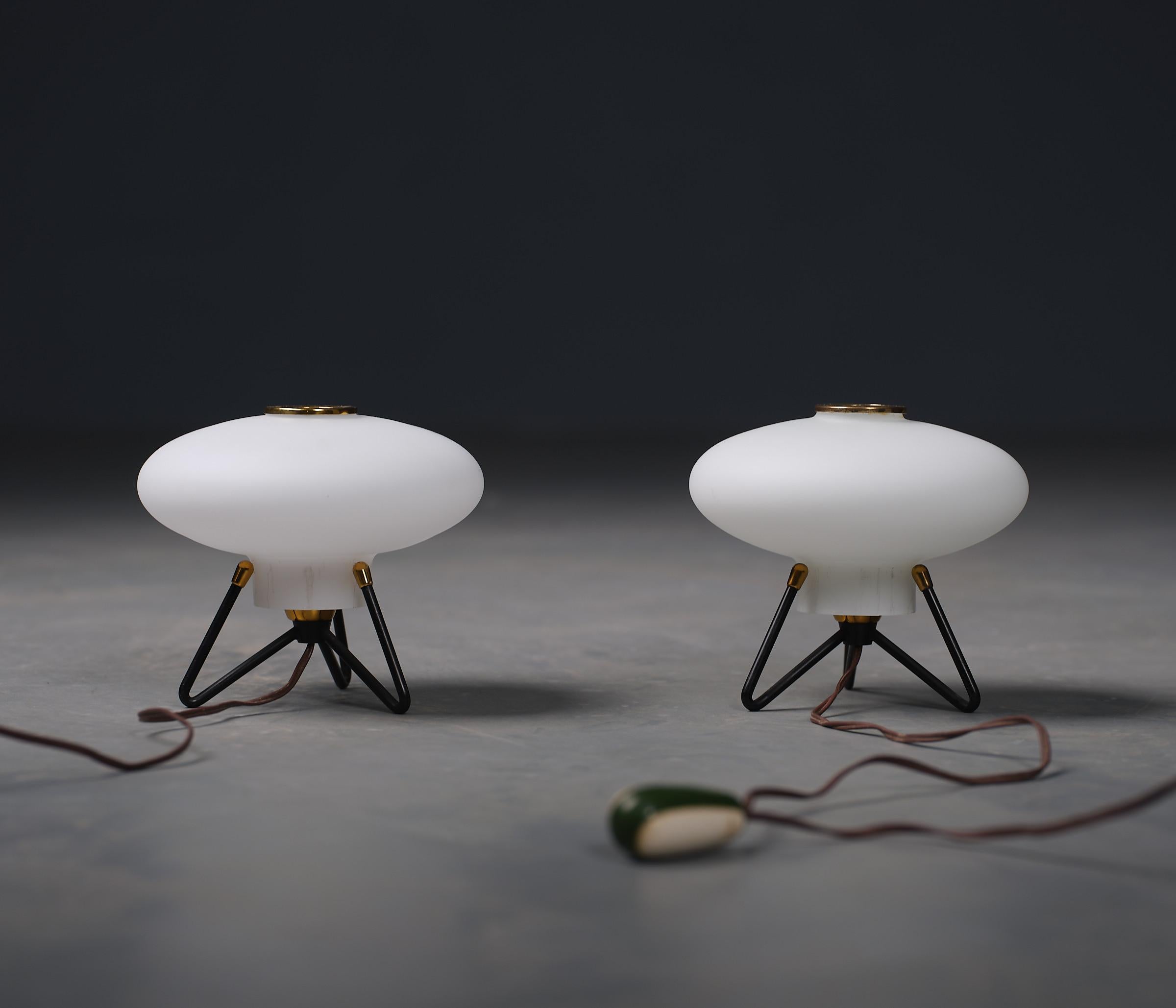 Introducing a captivating pair of table lamps that echo the futuristic themes of the 1950s, attributed to the design ethos of STILNOVO. These lamps are beautifully preserved, showcasing only minimal signs of wear which lend authentic vintage appeal