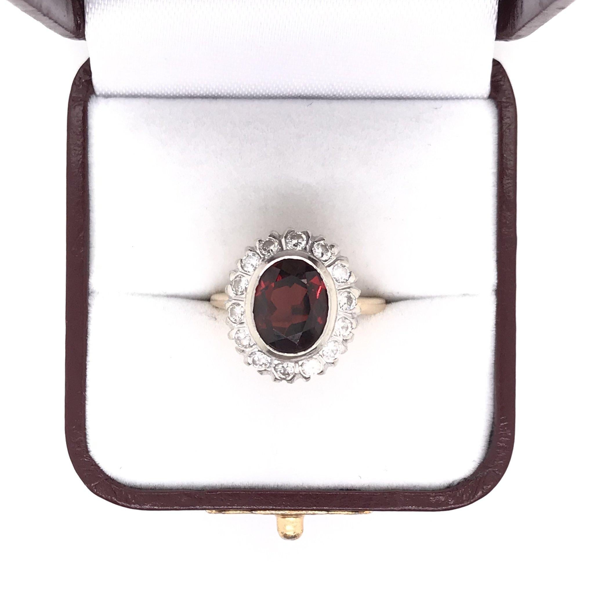 This garnet ring was crafted sometime during the Mid Century design period ( 1940-1960 ). The center stone is a garnet measuring approximately 2.50 carats. The garnet is the traditional reddish brown hue and has a gorgeous saturation. The center