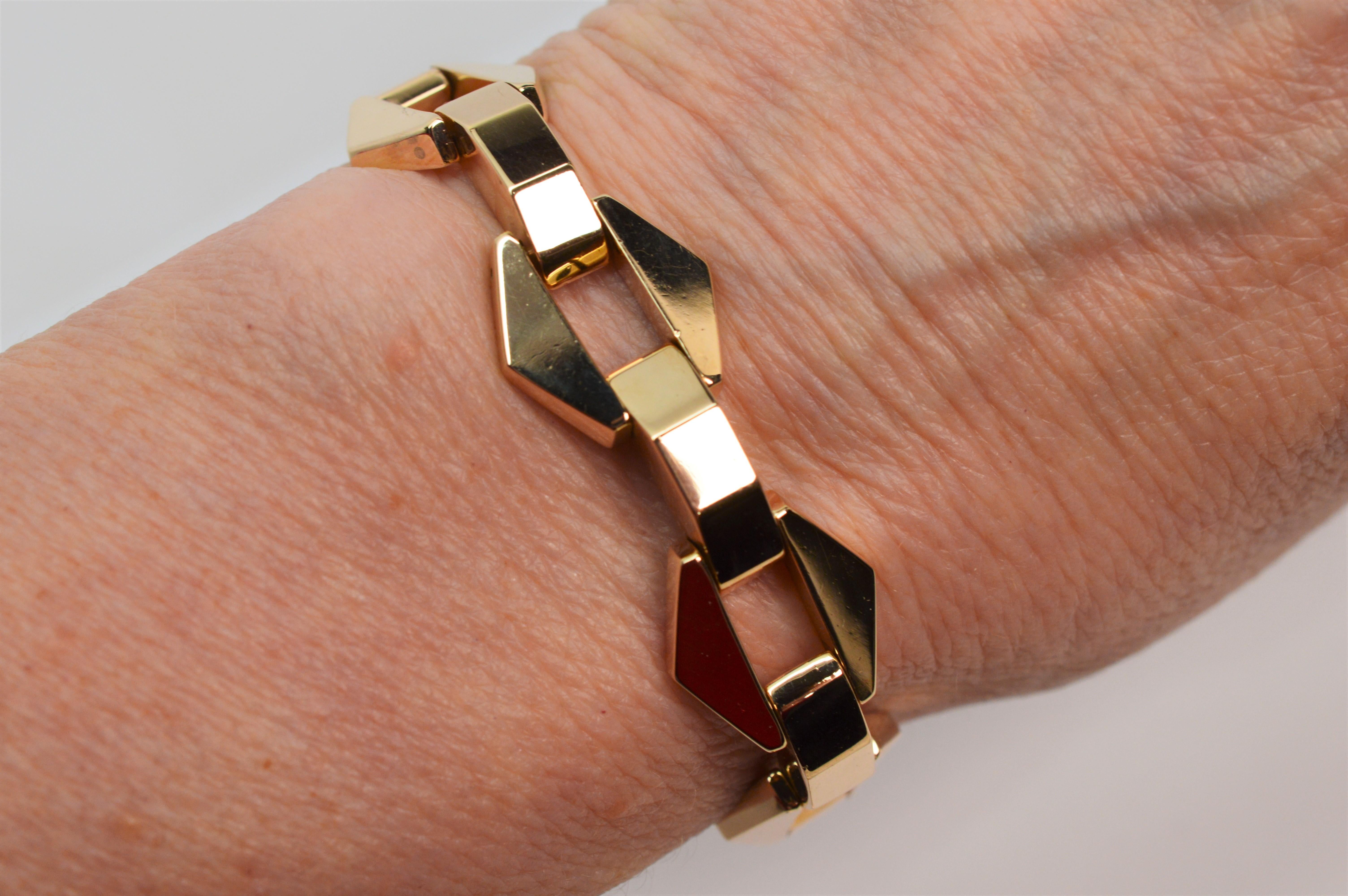 Open geometric links give this retro fourteen karat 14k yellow gold bracelet added interest. Circa 1960's, this estate piece measures 6.5 inch in length and is 5/8 inch wide. The bracelet has a matching link closure and safety chain. With it's