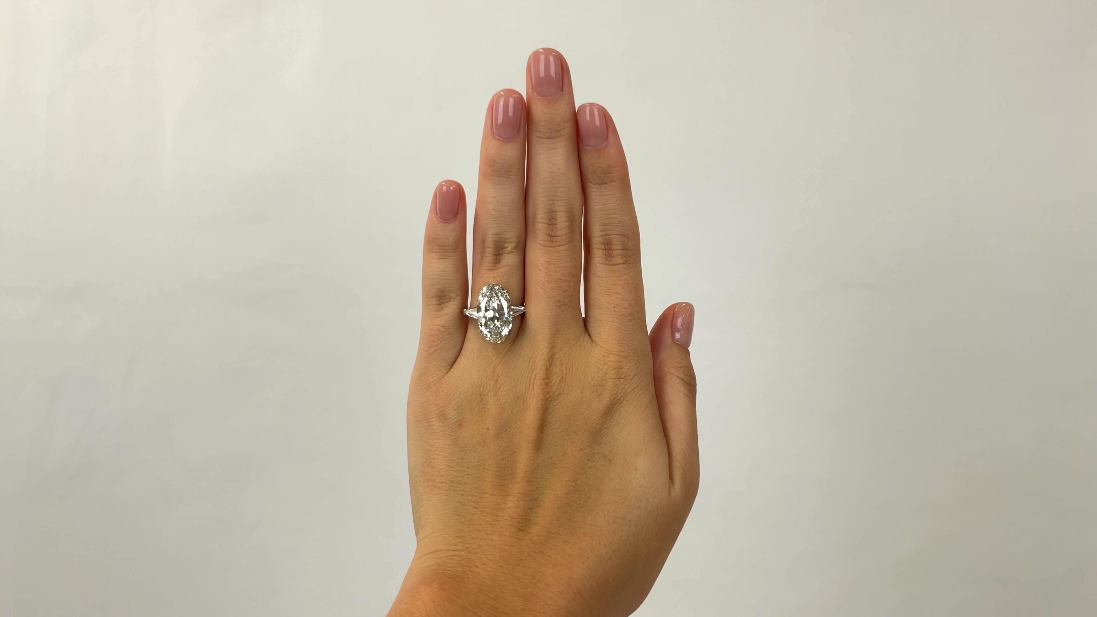 One Retro GIA 6.16 Carat Antique Oval Cut Diamond Platinum Engagement Ring. Featuring one GIA certified 6.16 carat antique oval diamond cut accompanied with certificate #2185530527 stating the diamond is I color, VS1 clarity. Accented by two tapered