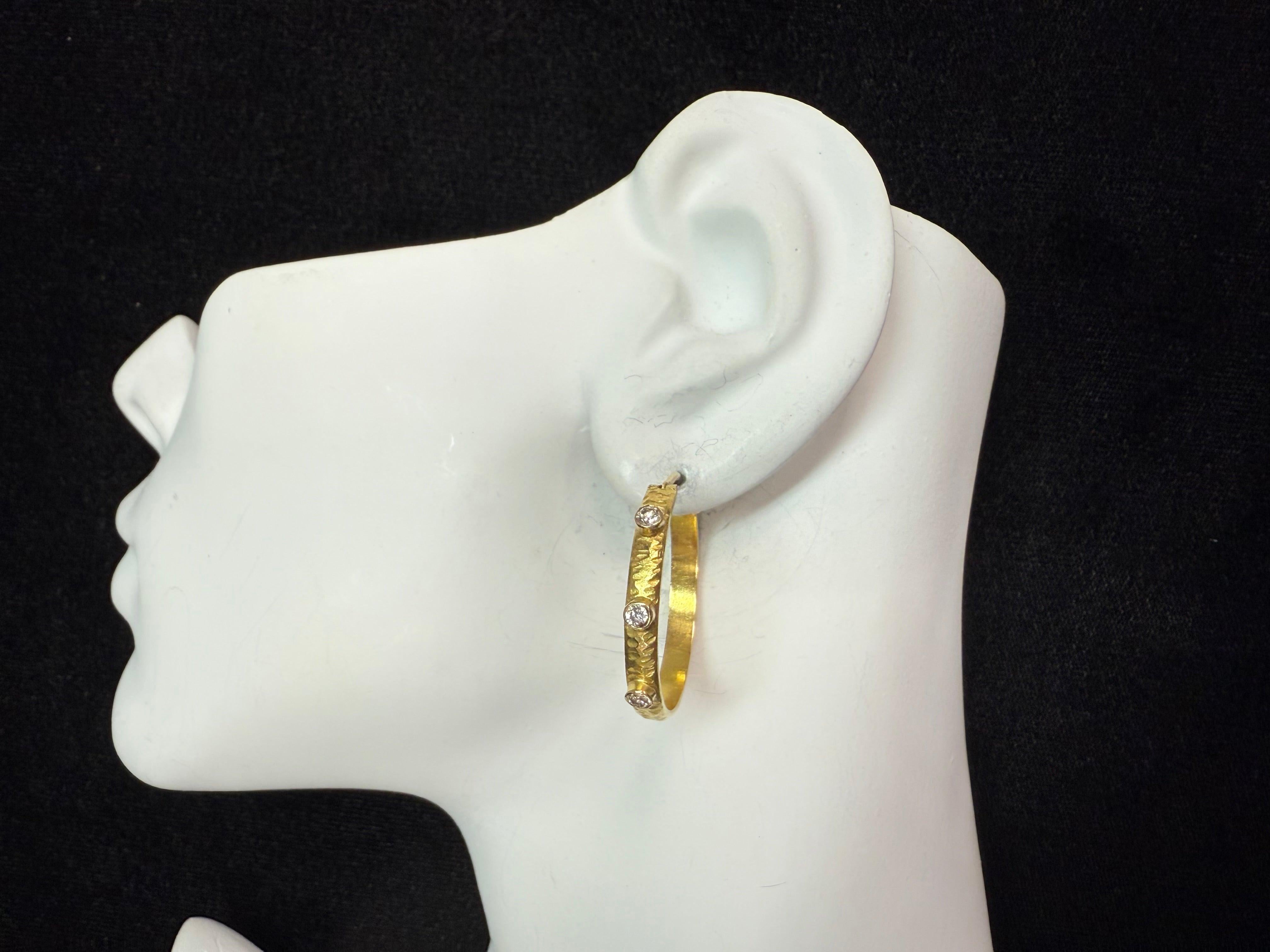 A refined pair of retro 18K gold hoop earrings with a hammered finish, set with natural colorless diamonds totaling approximately 0.30 carat. These elegant hoops measure 30 mm in diameter and 3.5 mm in width, and weigh a total of 9 grams. A timeless