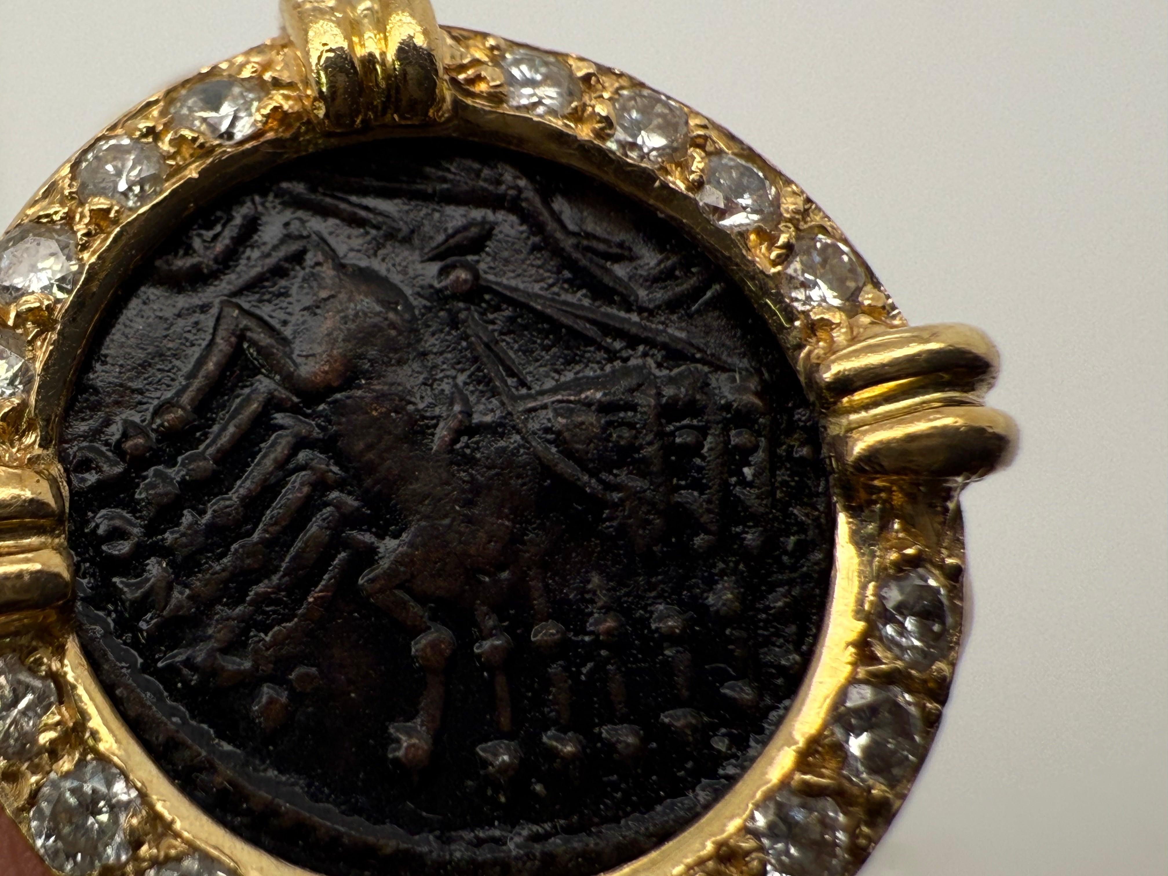 Anello retrò in oro con un'antica moneta europea in bronzo, incorniciata da 16 diamanti naturali incolori per un totale di circa 0,50 carati. 
L'anello misura 18 mm nella parte superiore con una fascia flessibile larga 13,5 mm, è una misura 5,25 e