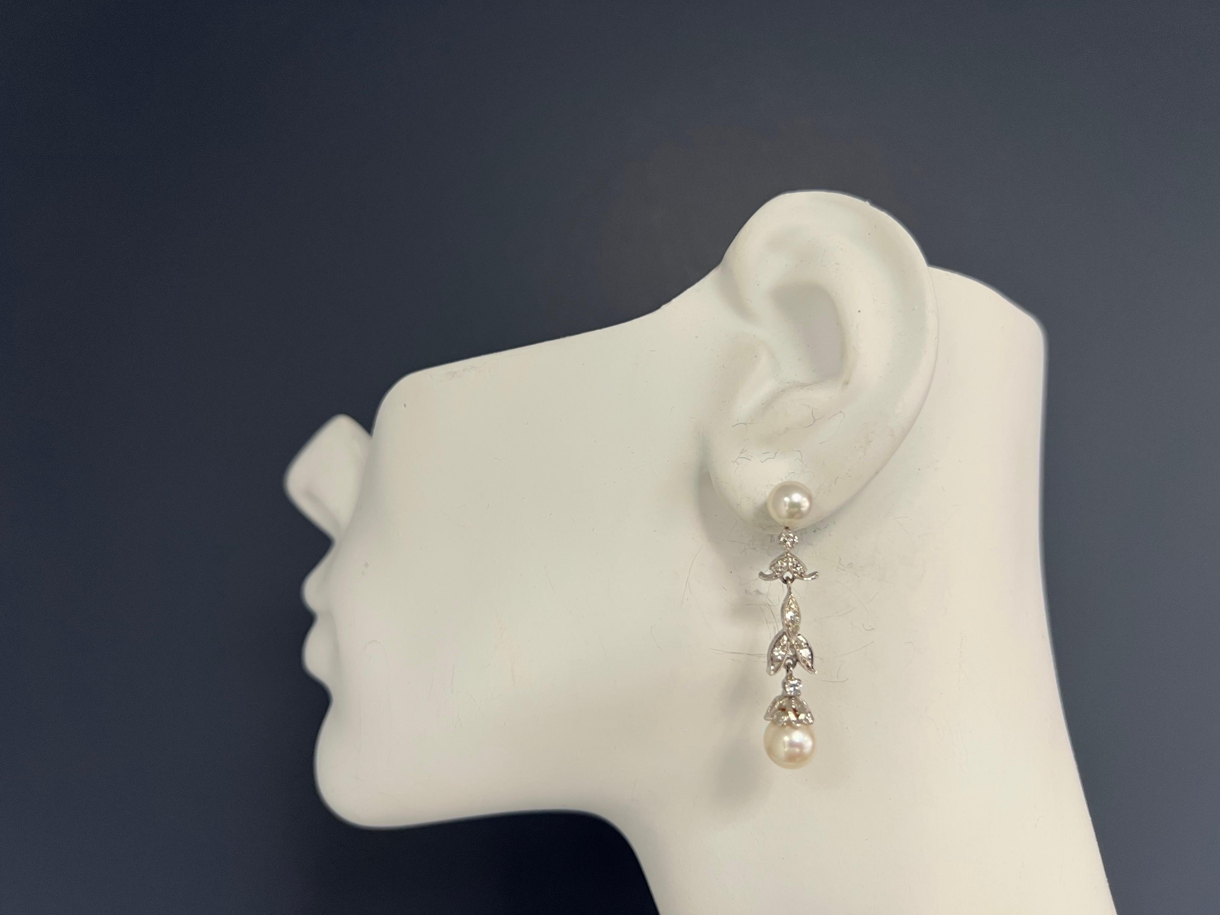 Retro 14k White Gold 0.50 Carat Natural Diamond & Pearl Drop Earrings Circa 1960.

The pearls are 6.5mm and 7.5mm respectively, set with 22 natural round brilliant diamonds, appx G in color and SI in clarity. 

Total weight is 7 grams.
 