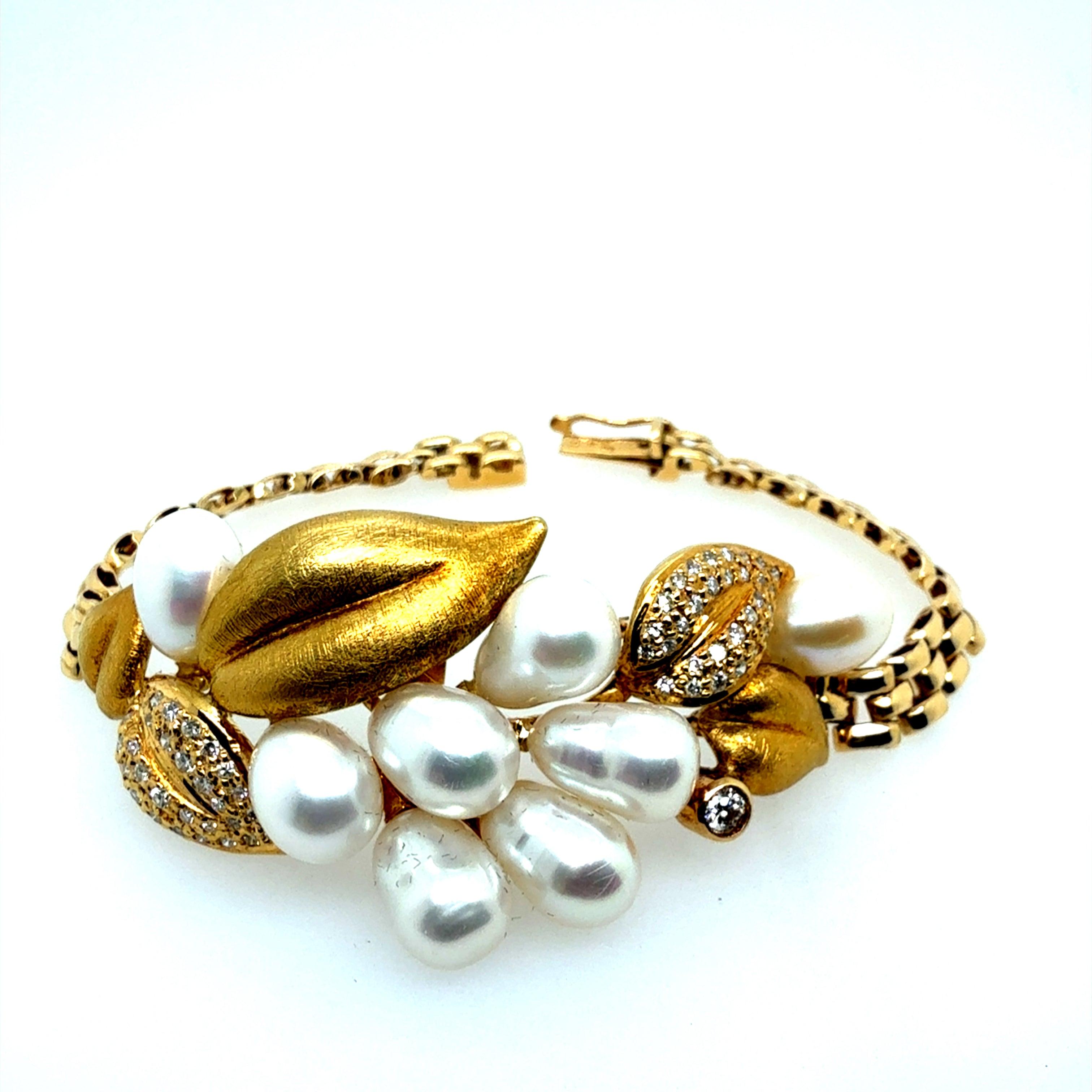 This rare handmade bracelet features a graceful leaf motif in 18K yellow gold, stamped 750 and weighing 25.1 grams. It measures 6.25 inches long, with a 5.25 mm wide band and a central section that widens to about 1 inch. 
Set with approximately