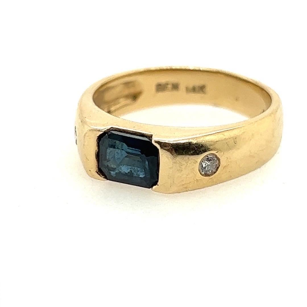Retro Gold 1.31 Carat Natural Diamond and Blue Sapphire Cocktail Ring Circa 1980

A stunning ring set with an approximate 1.25 carat natural blue emerald cut sapphire measuring 7.5x5.1x3.3mm. Included are two natural round brilliant diamonds