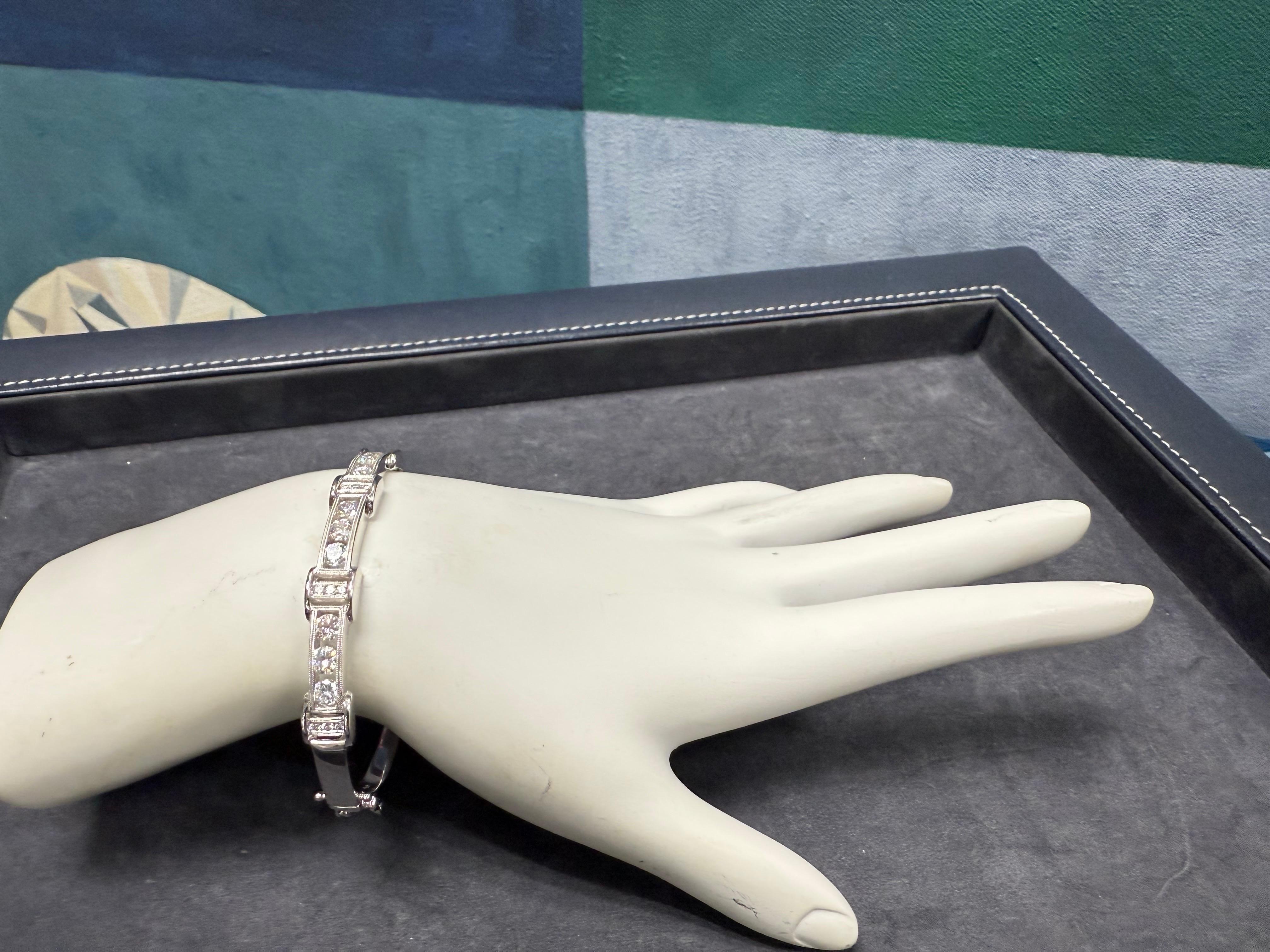 Splendido bracciale bangle in oro bianco 18 carati dal design unico con incastonatura a tensione, centrato da un diamante tondo brillante naturale di circa 1,8 carati, incolore e brillante. Il bracciale è dotato di due chiusure di sicurezza e di una