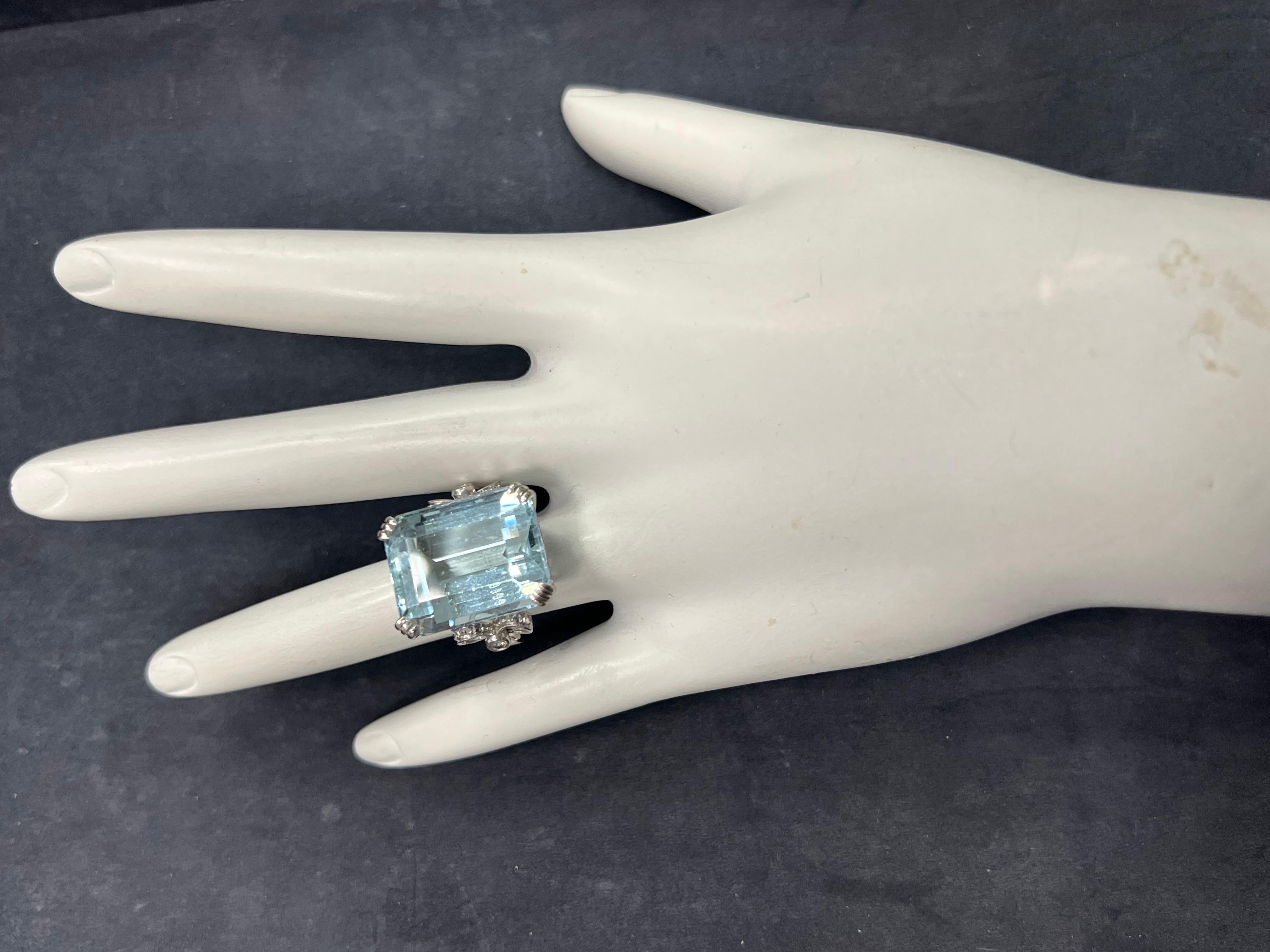 A magnificent 18K White Gold Aquamarine and Diamond Ring.

The centerstone is an approximately 20 carat emerald cut natural aquamarine measuring 18.53x14.74x10.67mm. The stone has slight abrasions. 

The ring is set with two round brilliant natural
