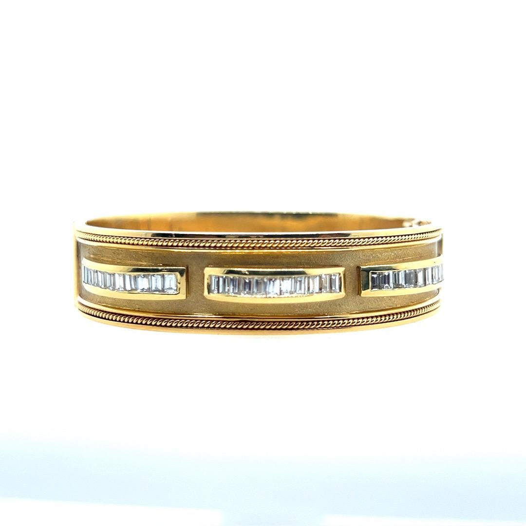 A Magnificent Retro 18k Yellow Gold (tested, not stamped) handmade bangle, set with 33 colorless (VS-SI) natural baguette diamonds weighing approximately 2.50 carats. The inner rim of the bangle measures 6.25