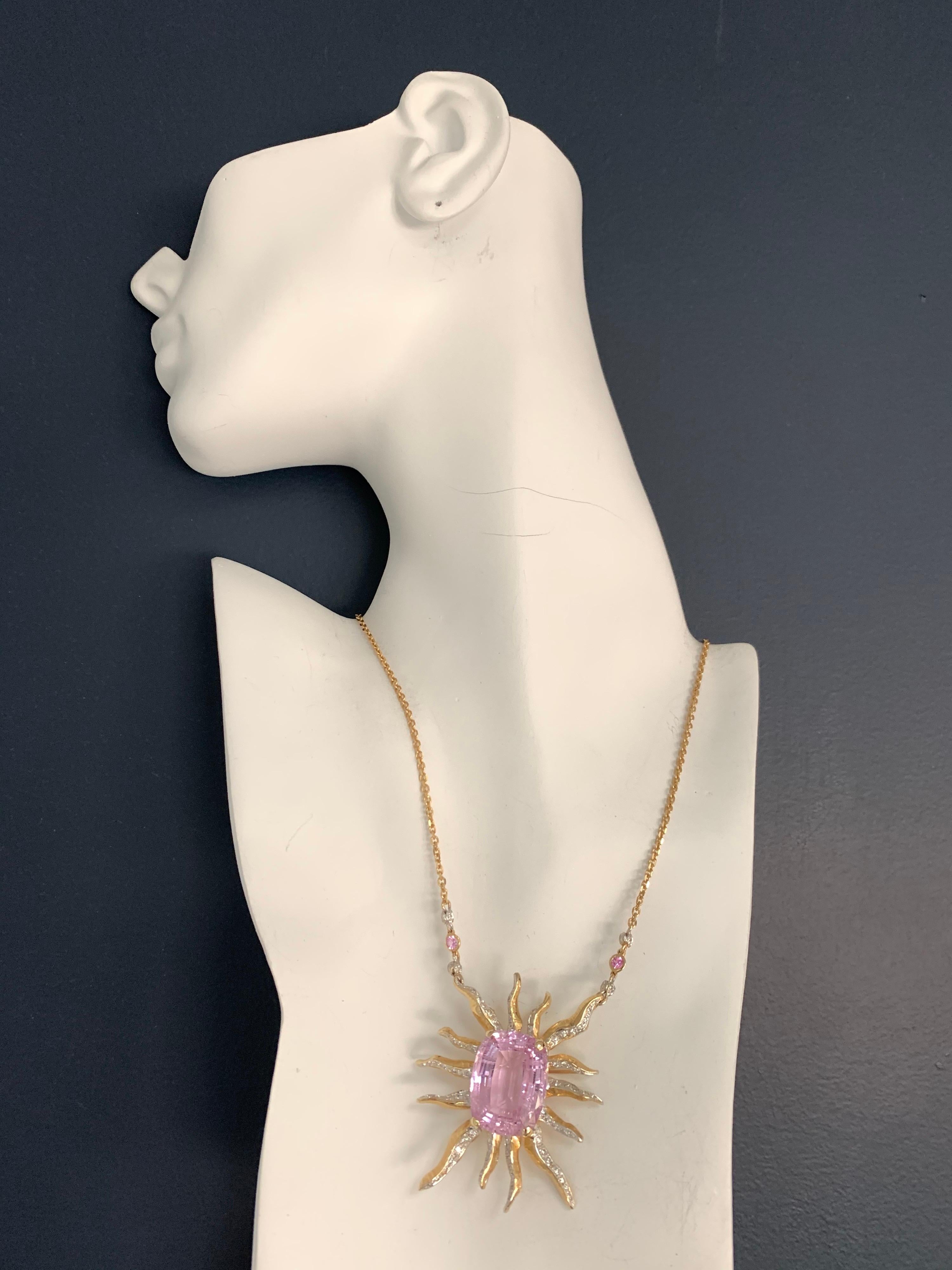 A Stunning 14k Gold Starburst Pendant set with an approximately 30 carat cushion shaped purplish pink Natural Kunzite measuring 23x18x11.2mm.

The piece is also set with 95 round brilliant diamonds weighing approximately 0.85 carats, G-H in color