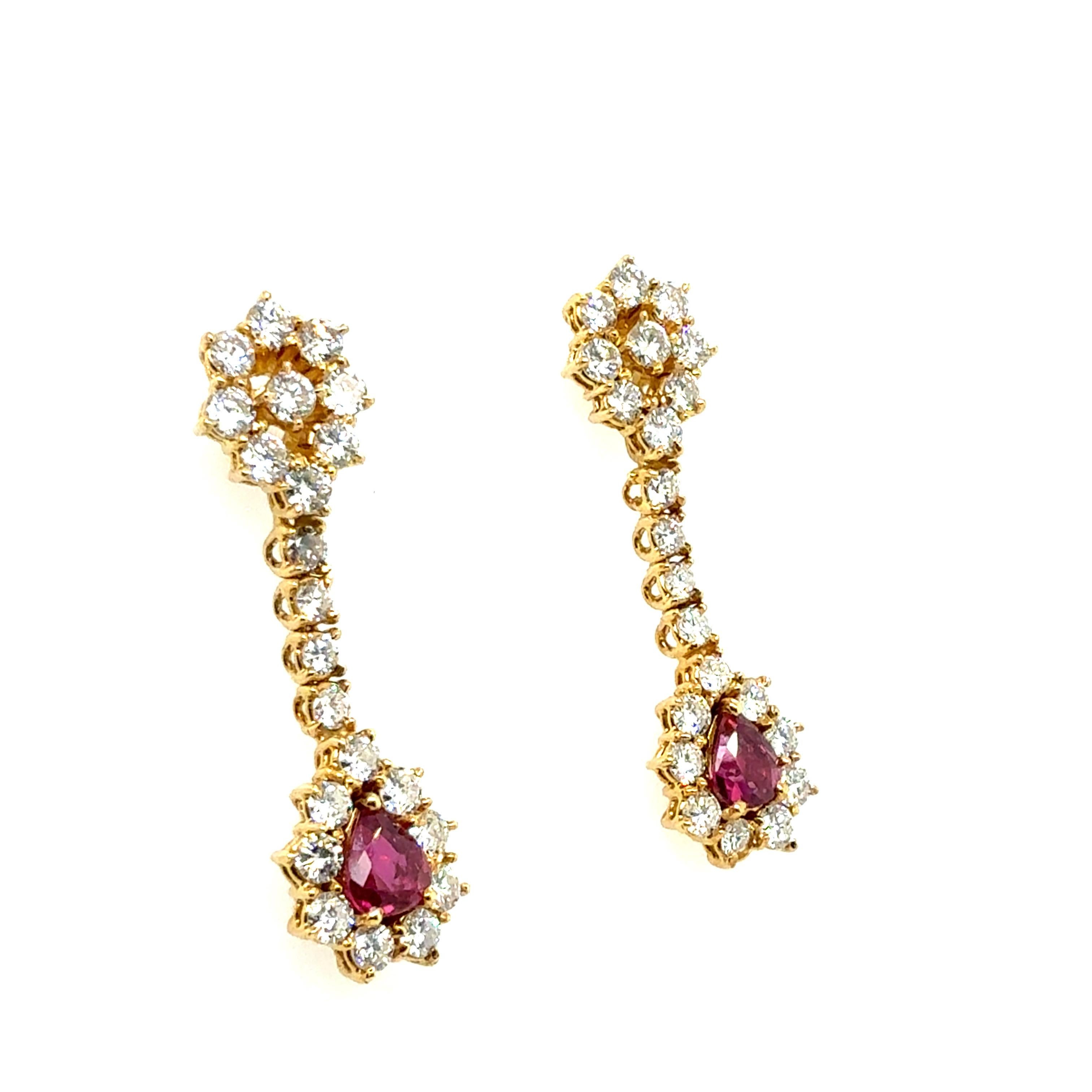 Retro yellow gold drop earrings, circa 1975, set with two natural pear-shaped Thai rubies weighing approximately 1.50 carats total and measuring about 6.5 × 5 × 2.7 mm each. Surrounding the rubies are 44 natural round brilliant diamonds weighing