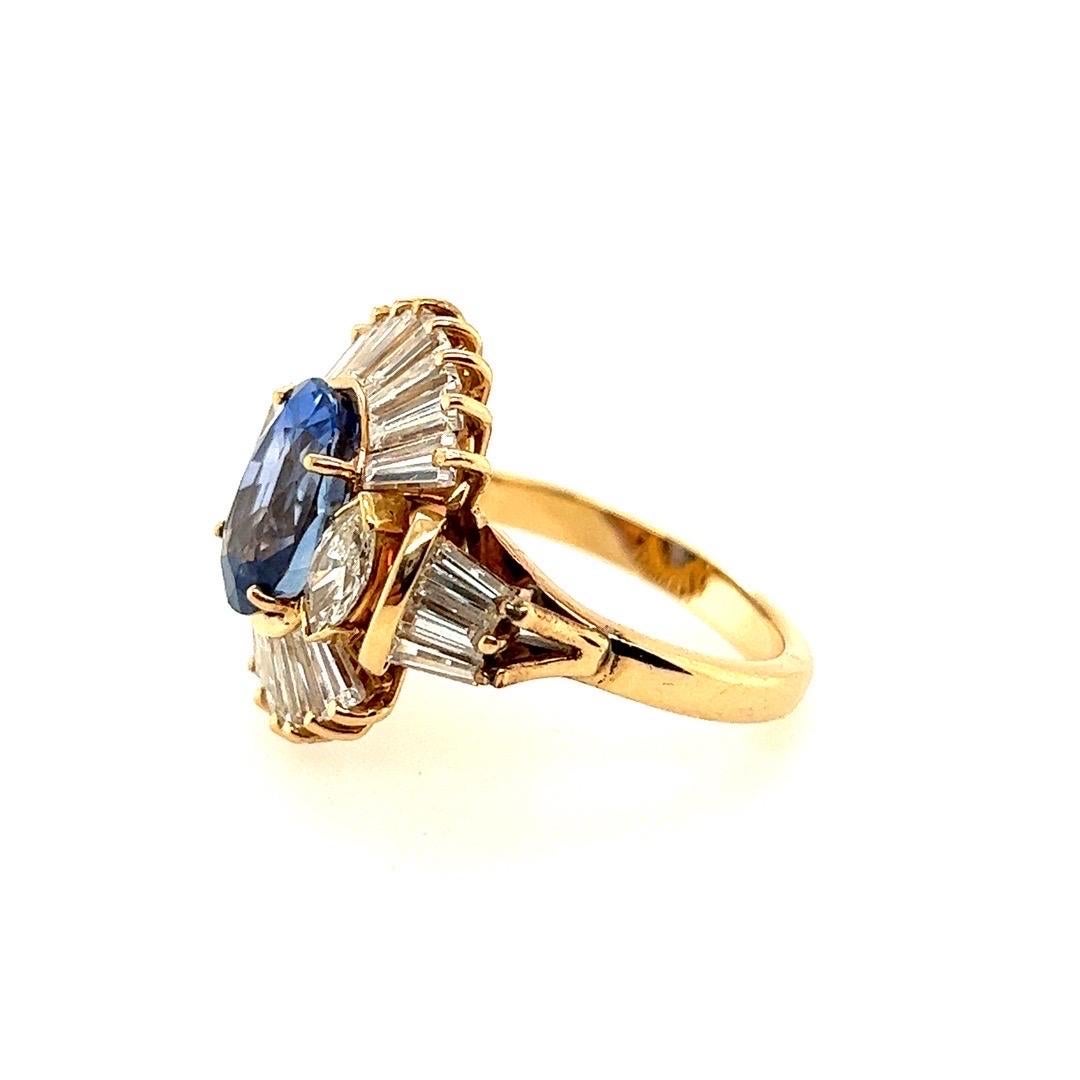 A magnificent 1960's cocktail 14k gold ring. 

Set with an approximate 4 carat blue oval sapphire measuring appx 10.38x7.51x6.14mm. The stone is also flanked with two natural marquise diamonds approximately I in color and weighing 0.55 carats. In