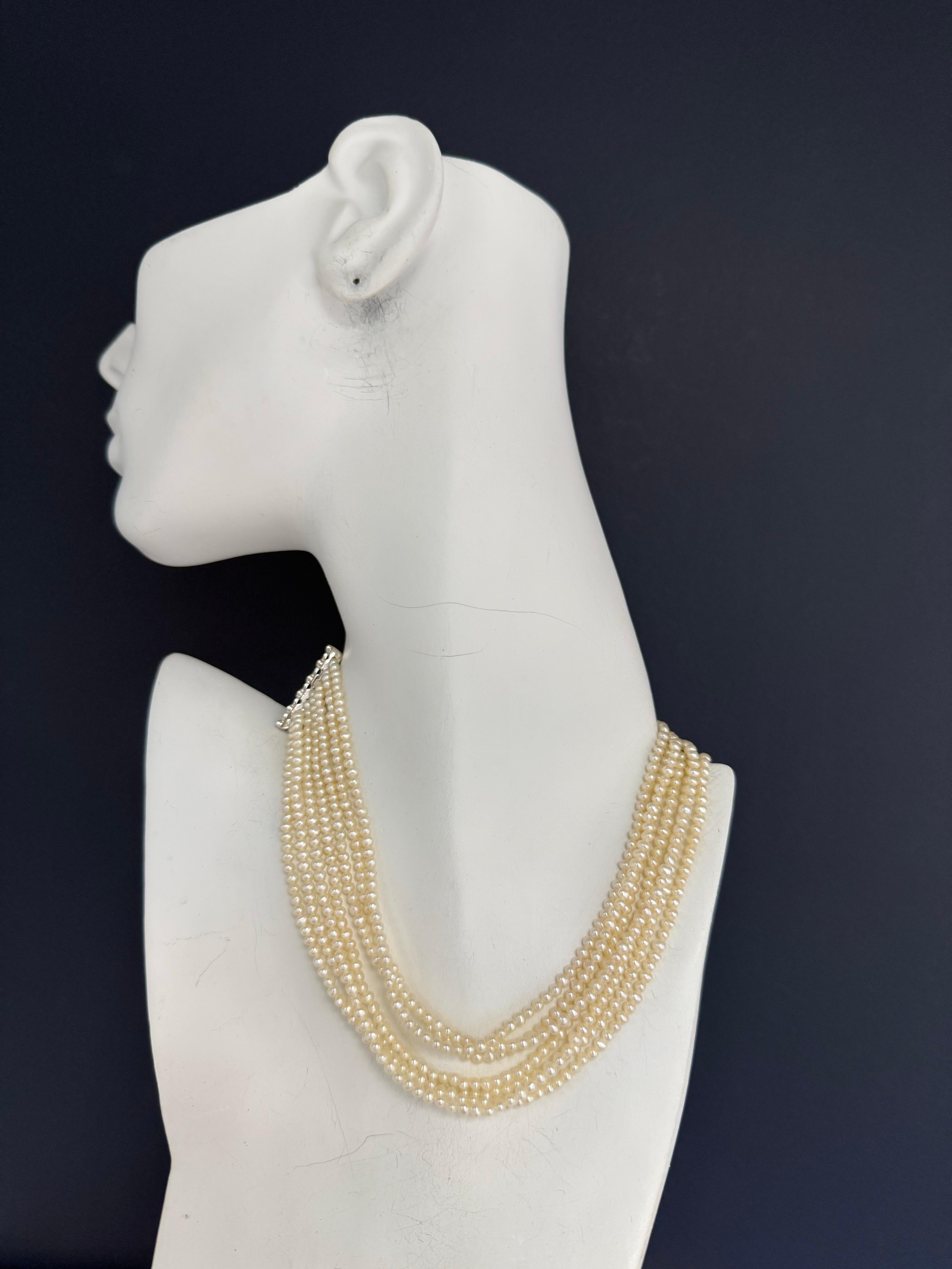 Whiting collana retro in oro bianco 18 carati a sette fili di perle, misura circa 14 pollici dal punto più corto. Ogni delicata perla misura circa 3 mm di diametro e il pezzo pesa circa 48 grammi in totale. 

La chiusura affusolata misura 1,25