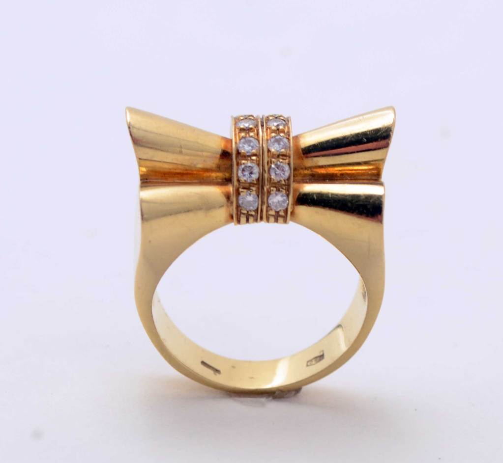 Questo anello a fiocco in oro e diamanti a diciotto carati ha un design assolutamente retrò. Molto scultoreo e interessante da tutte le angolazioni. La taglia è la 7, ma può essere facilmente aumentata o diminuita.