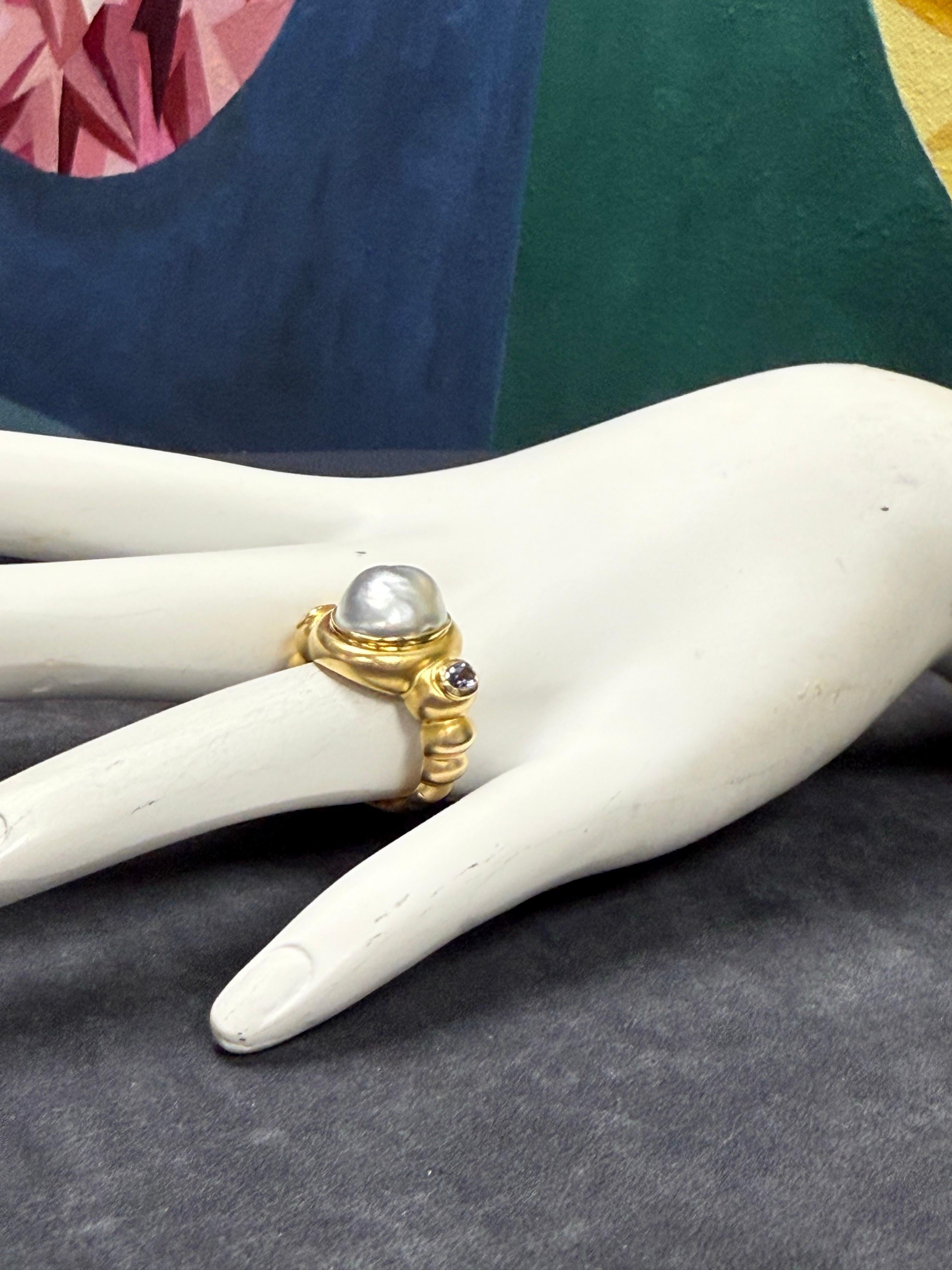 Bague rétro en or circa 2000, présentant une perle gris baroque très brillante, rehaussée d'une améthyste naturelle et d'un péridot. La partie supérieure mesure environ 16,8 mm de large, avec une bande allant de 8 mm à 3 mm. La bague est de taille