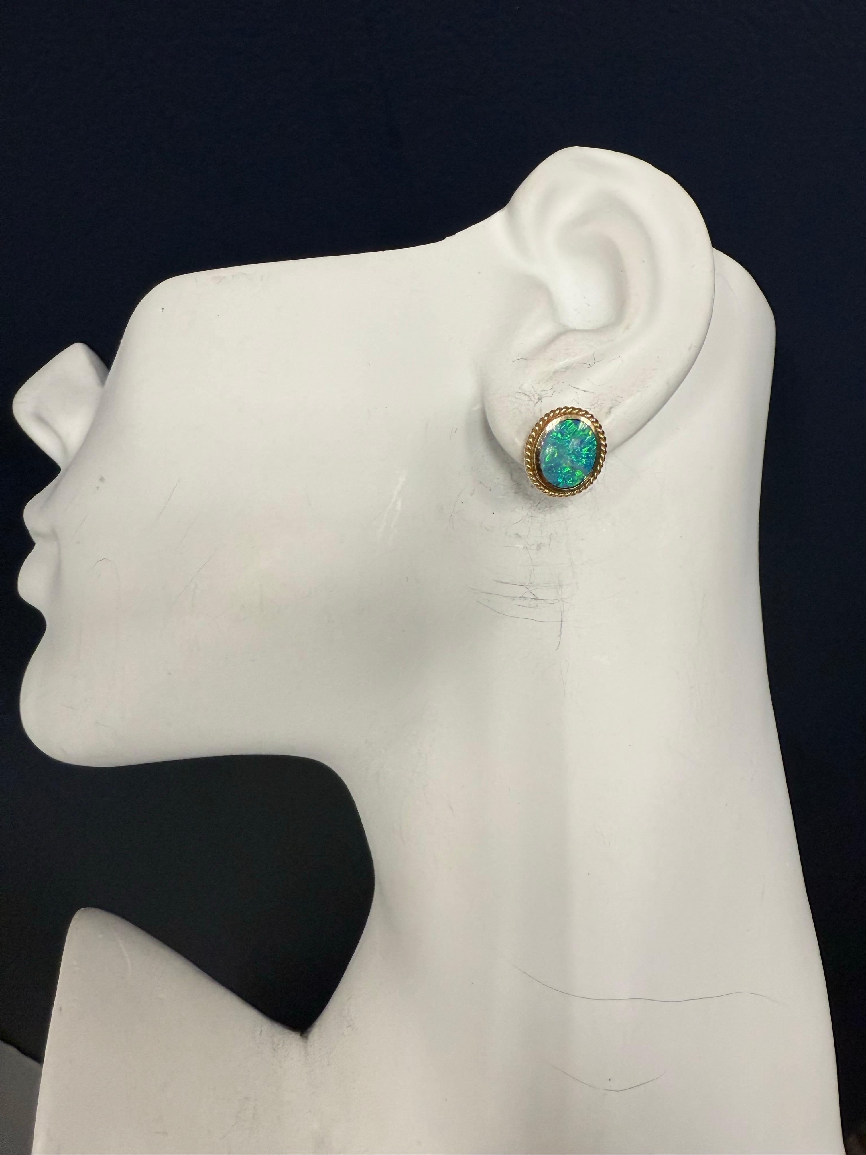 Boucles d'oreilles rétro en or jaune 14K ornées d'opales naturelles, circa 1980. La paire mesure environ 13,4 × 11,7 mm au total et pèse 3 grammes. 

Poinçonnées 14 carats, elles mettent en valeur le travail rétro classique avec des opales qui